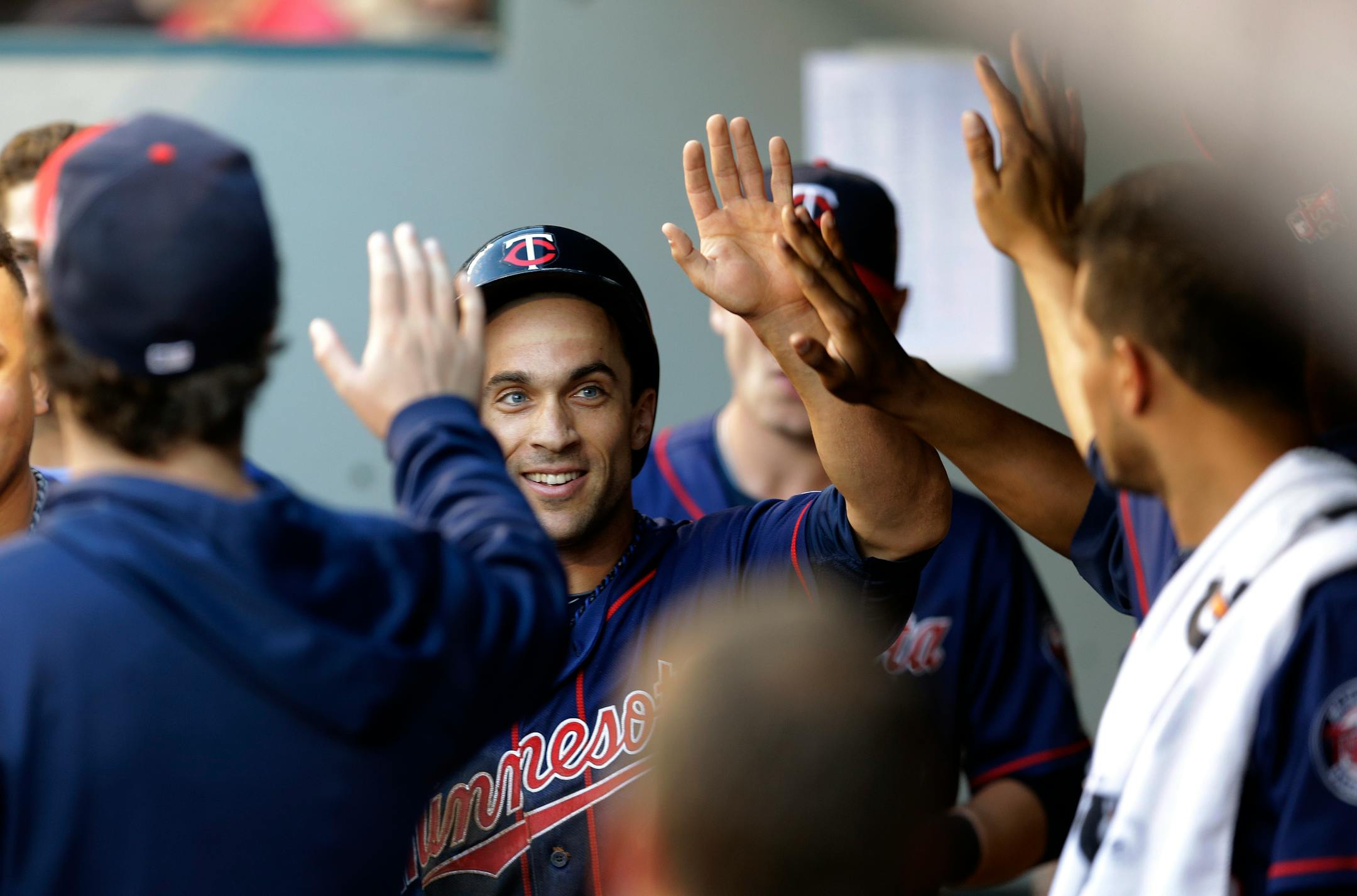 Minnesota Twins' Sam Fuld slaps hands in the dugout after scoring against the Seattle Mariners in the third inning of a baseball game, Thursday, July 10, 2014, in Seattle. (AP Photo/Ted S. Warren)