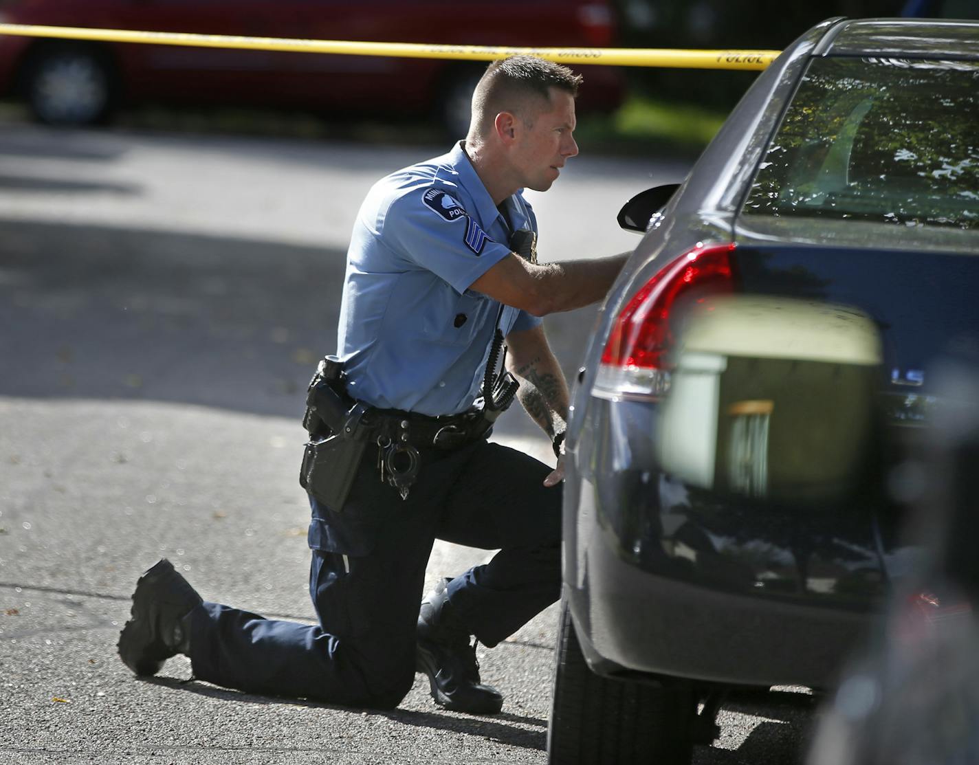 Two blocks west of Edison H.S. in Minneapolis on September 21, 2014, police officers examined the crime scene where a homocide occurred.]Richard Tsong-Taatarii/rtsong- taatarii@startribune.com ORG XMIT: MIN1409211243484269