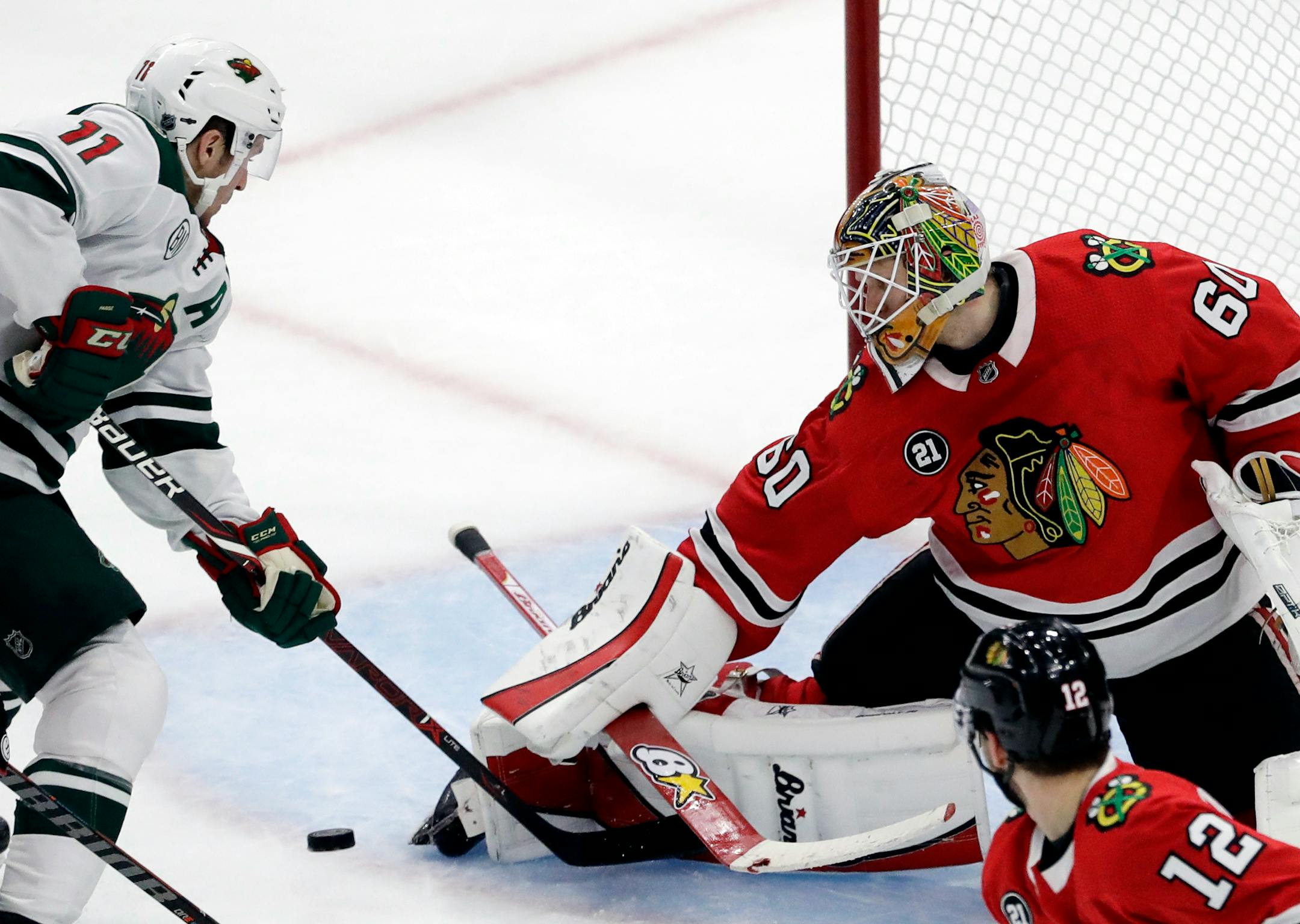Chicago Blackhawks goalie Collin Delia, right, blocks a shot by Minnesota Wild left wing Zach Parise (11) during the third period of an NHL hockey game Thursday, Dec. 27, 2018, in Chicago. The Blackhawks won 5-2. (AP Photo/Nam Y. Huh)p