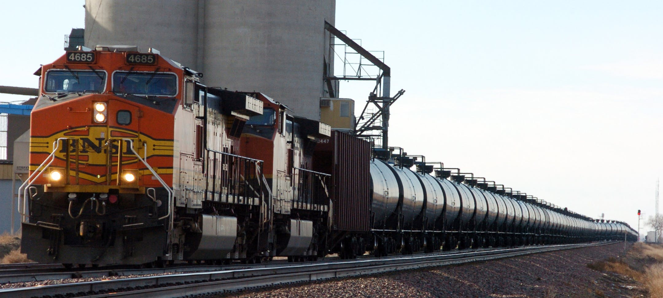 FILE - This Nov. 6, 2013, file photo, shows a BNSF Railway train hauling crude oil near Wolf Point, Mont. Railroads that haul volatile crude shipments have reached an agreement with U.S. transportation officials to adopt wide-ranging voluntary safety measures after a string of explosive and deadly accidents. (AP Photo/Matthew Brown, File)