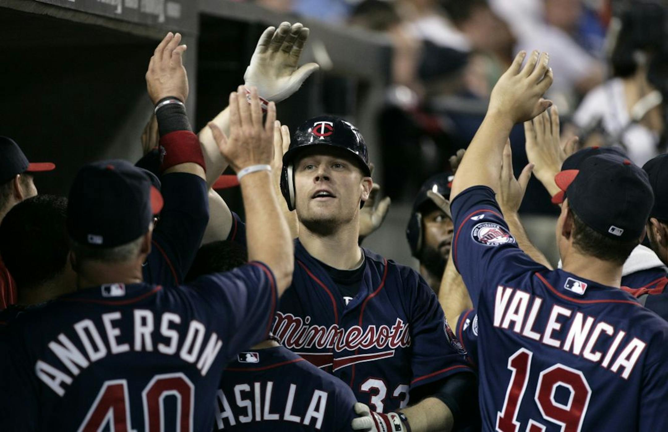 Minnesota Twins' Justin Morneau, center, is congratulated by pitching coach Rick Anderson (40), Alexi Casilla and Danny Valencia (19) after hitting his second home run of the night in the seventh inning of a baseball game against the Detroit Tigers Tuesday, May 31, 2011 in Detroit. The Tigers defeated the Twins 8-7.