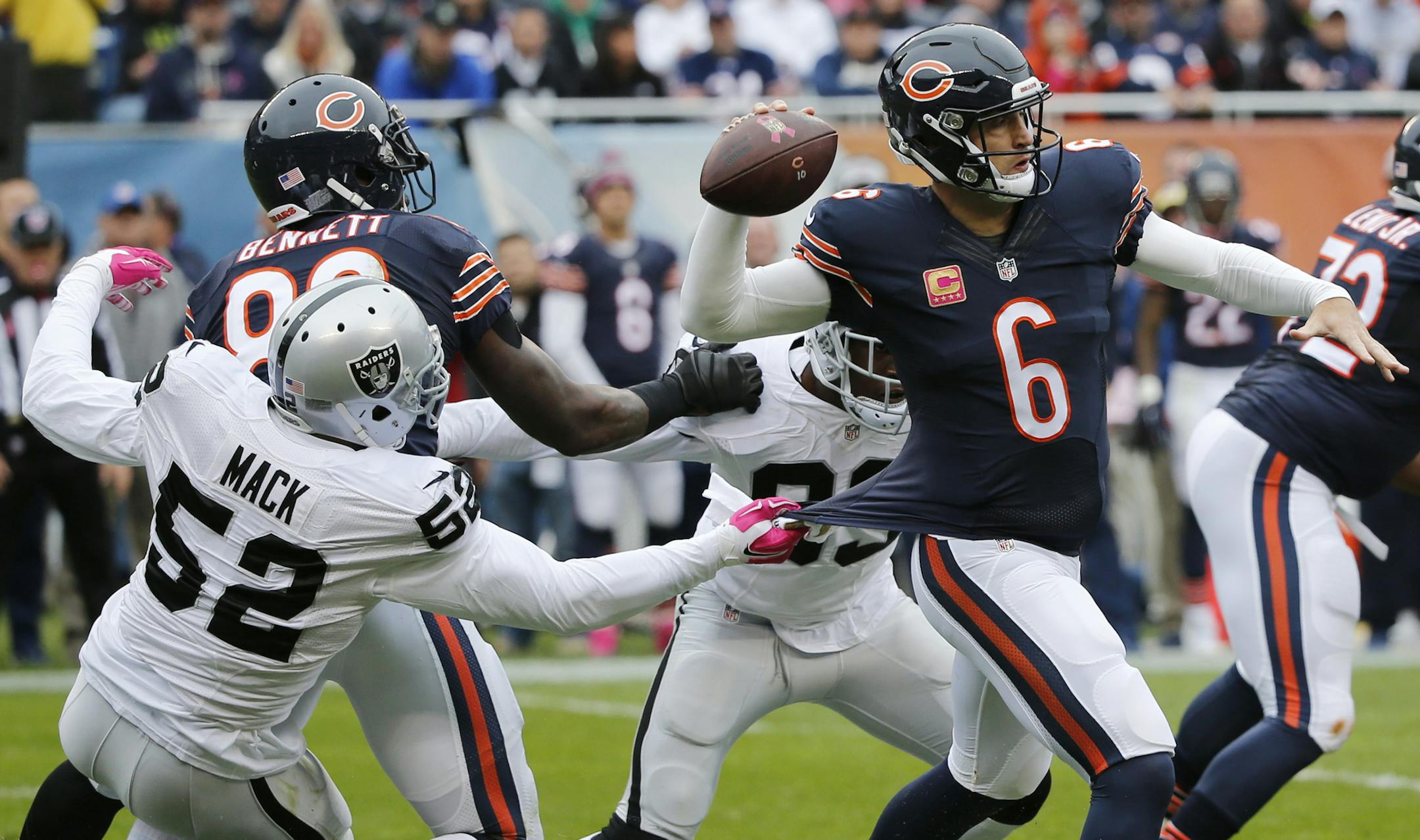 Chicago Bears quarterback Jay Cutler (6) tries to throw a pass as Oakland Raiders defensive end Khalil Mack (52) grabs his shirt during the first half of an NFL football game, Sunday, Oct. 4, 2015, in Chicago. (AP Photo/Charles Rex Arbogast)