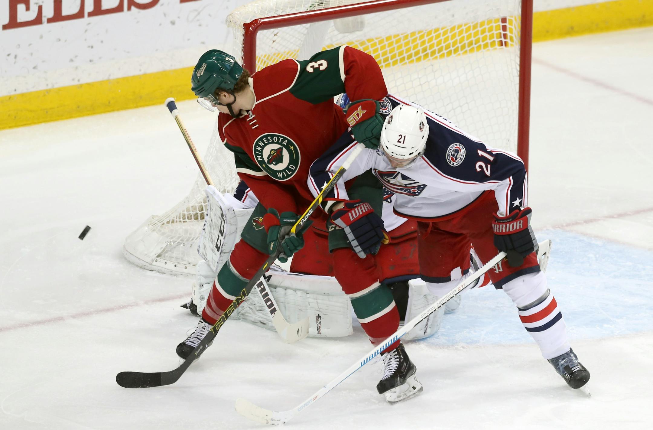 A shot gets past Minnesota Wild's Charlie Coyle, left, as Columbus Blue Jackets' James Wisniewski defends in the first period of an NHL hockey game, Monday, Jan. 19, 2015, in St. Paul, Minn. (AP Photo/Jim Mone)