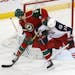 A shot gets past Minnesota Wild's Charlie Coyle, left, as Columbus Blue Jackets' James Wisniewski defends in the first period of an NHL hockey game, M