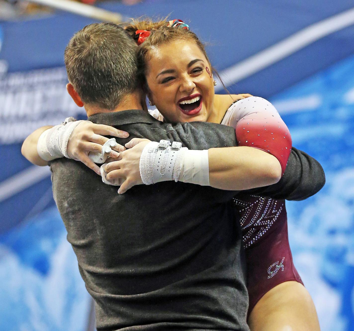 Maggie Nichols hugs Lou Ball, one of Oklahoma assistant coaches, during the national championship meet in St. Louis, April 21, 2018.