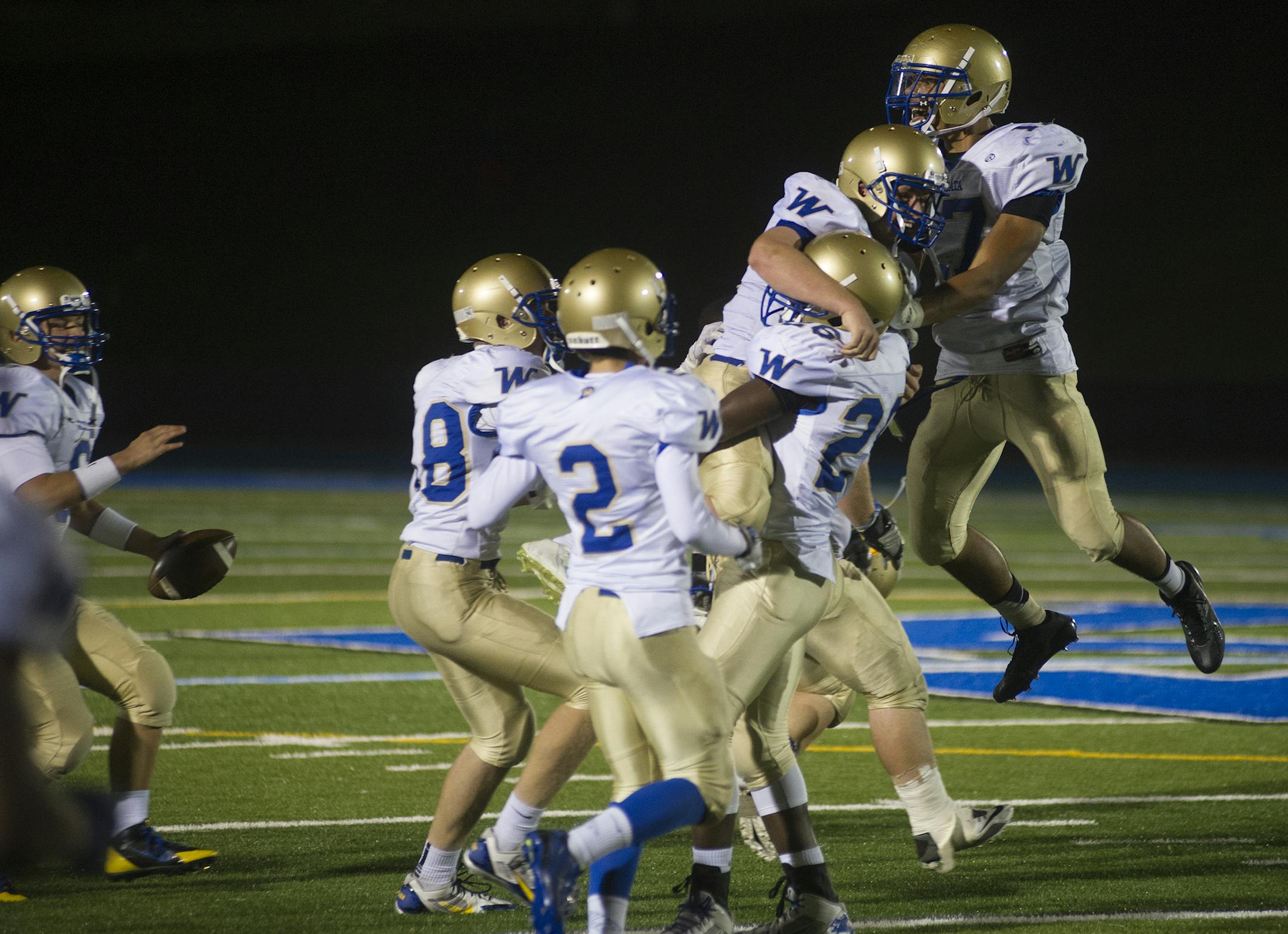 Wayzata's Christian Thomas leaps onto the back of Ethan Faust who is hoisted by teammate Keeshawn Aleksuk in celebration after defeating Minnetonka 31-28 at home Friday, October 24, 2014. ] (Matthew Hintz, 102414, Minnetonka)