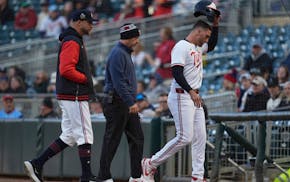 The Twins' Matt Wallner, right, leaves the game with manager Rocco Baldelli and a trainer after suffering a hamstring injury against the New York Mets