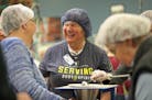 Several groups gathered at the workstation tables inside Feed My Starving Children in Coon Rapids on Give To The Max day. FMSC received an additional 