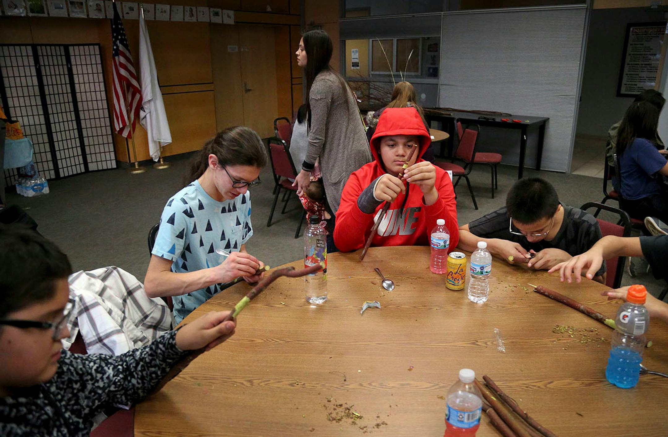 A state-funded workshop on harvesting traditional tobacco from red osier dogwood, also known as red willow, took place Saturday, Dec. 16, 2017 on the Lower Sioux Indian Reservation near Morton, MN. Here, young Lower Sioux Community members use spoons to shave off the bark from the red willow before harvesting the traditional tobacco from the limbs.