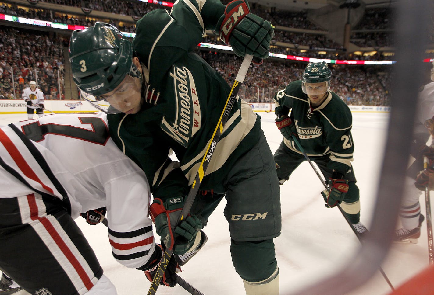 Minnesota Wild center Charlie Coyle (3) and Minnesota Wild right wing Nino Niederreiter (22), played defense at the boards against Chicago Blackhawks defenseman Sheldon Brookbank (17) in the second period of Game 3.