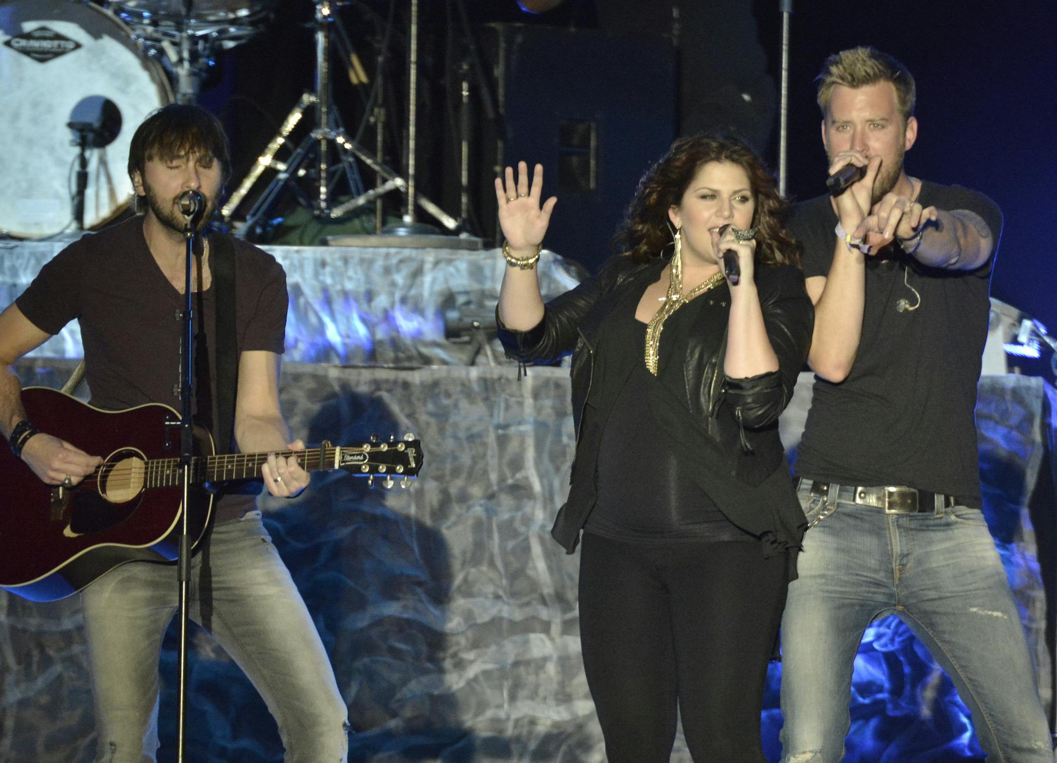 From left to right, singer Charles Kelley, singer Hillary Scott, and musician Dave Haywood of the band Lady Antebellum perform on Day 2 of the 2013 Stagecoach Music Festival at the Empire Polo Club on Saturday, April 27, 2013 in Indio, Calif. (Photo by Dan Steinberg/Invision/AP) ORG XMIT: MIN2013060414163573