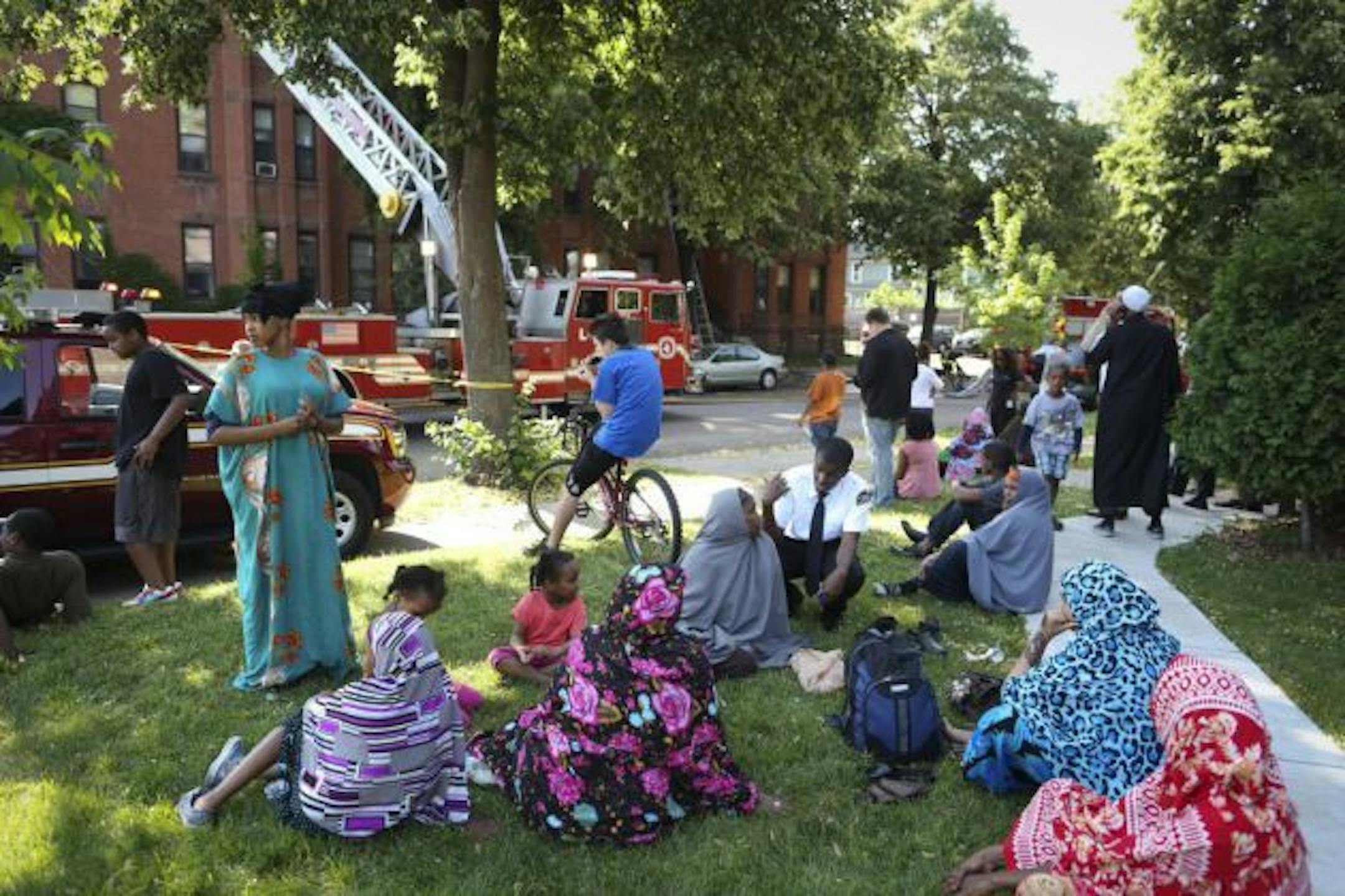 A crowd gathered outside at the scene of an apartment fire at 19th St. and 10th Av. S. that sent one woman to the hospital on Monday, June 25, 2012 in Minneapolis, Minn.  ](RENEE JONES SCHNEIDER ' reneejones@startribune.com)