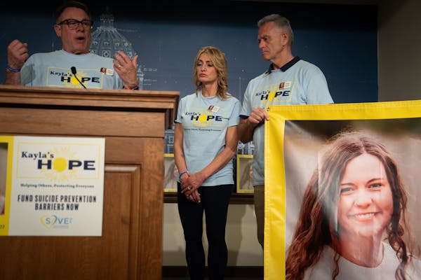 MJ Weiss and her fiancé Dale Blair, right, listen as Mike Freeman speaks at a State Capitol press conference on April 25.