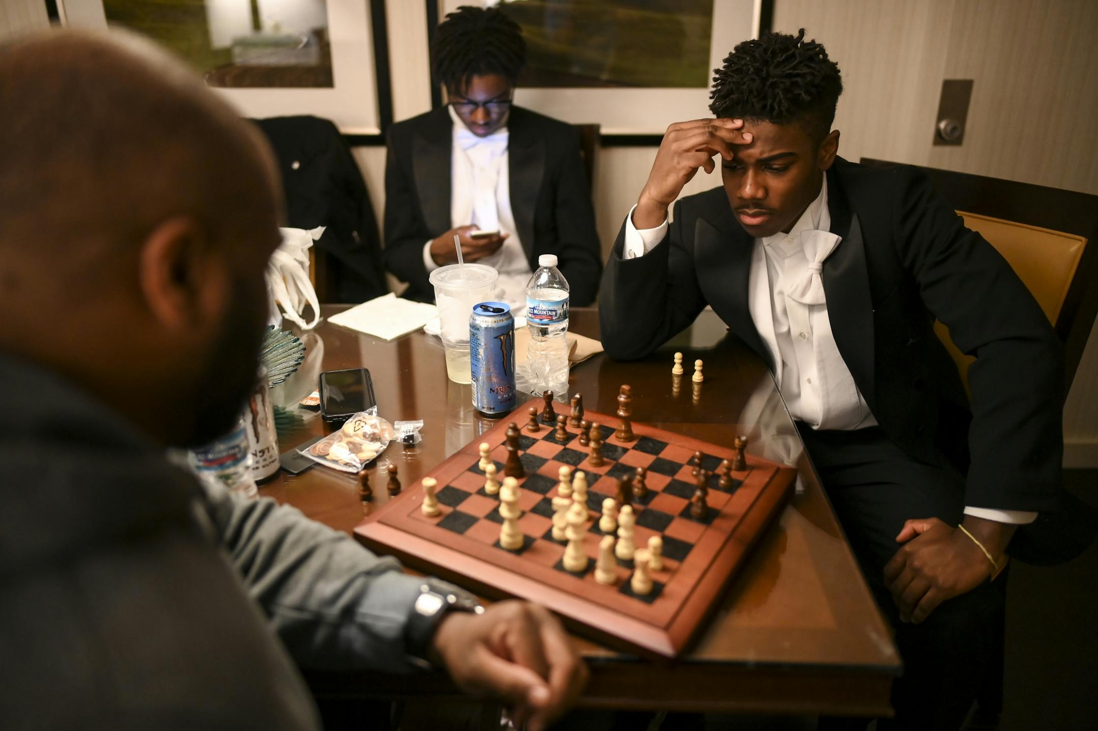 Breck student Derek Turner III, a junior escort for debutante Tomi Ijiyode, played a game of chess with chaperone Brett Carmichael, of Maple Grove, as they waited for the start of Saturday night's winter cotillion in a Marriott suite.