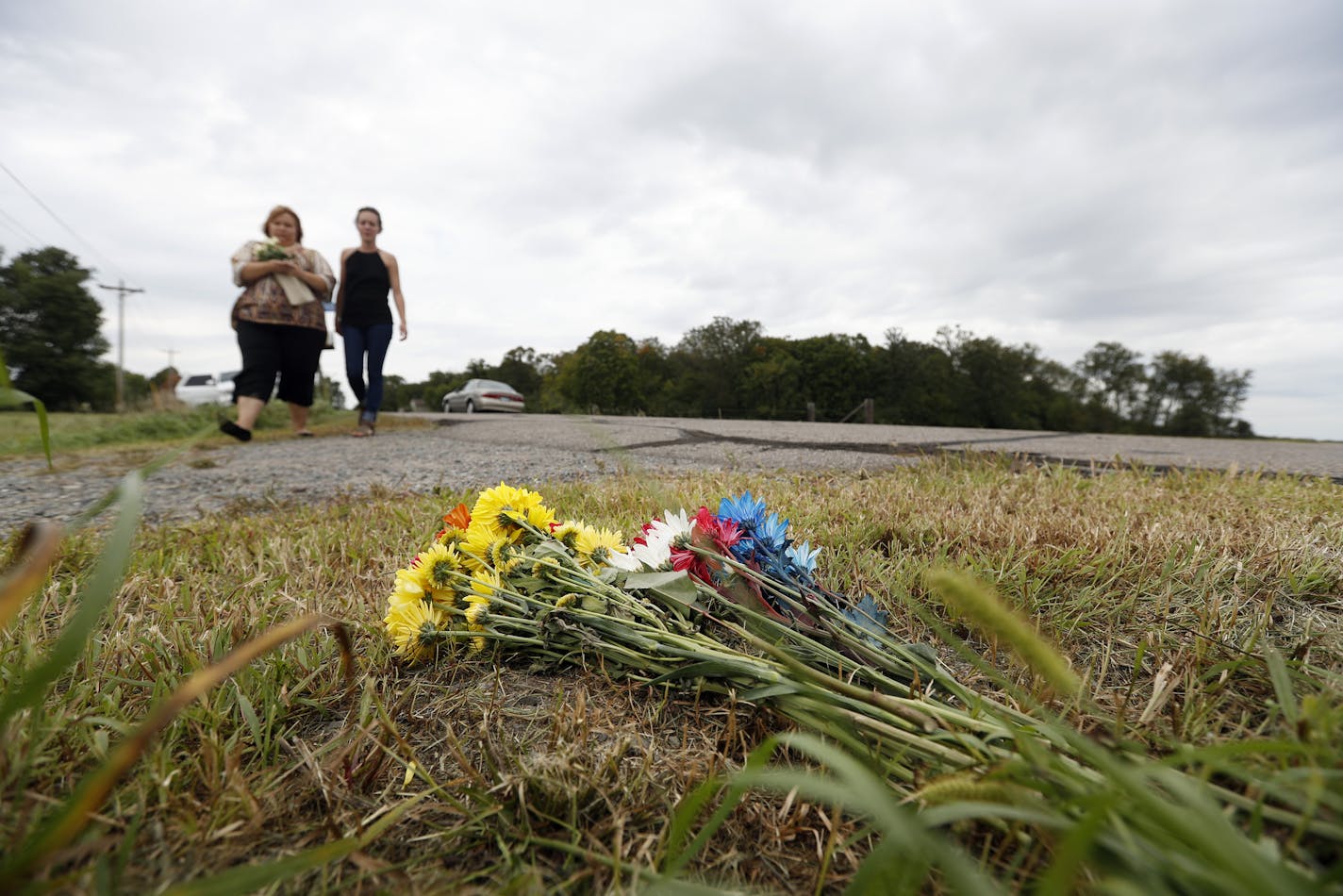 Casie Smith, left, and Emily Schmidt, both 27, brought flowers to the site in St. Joseph, Minn., where Jacob Wetterling was abducted 27 years ago.