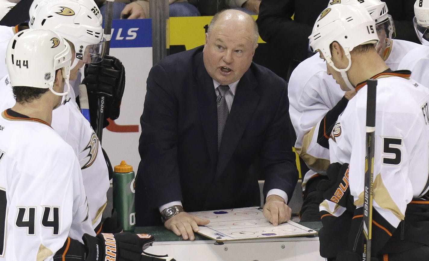 Anaheim Ducks head coach Bruce Boudreau, center, talks out a play with Sheldon Souray (44) and Luca Sbisa (5) during the third period of an NHL hockey game against the Dallas Stars Friday, Feb. 8, 2013, in Dallas. The Stars won 3-1. (AP Photo/LM Otero) ORG XMIT: DNA115