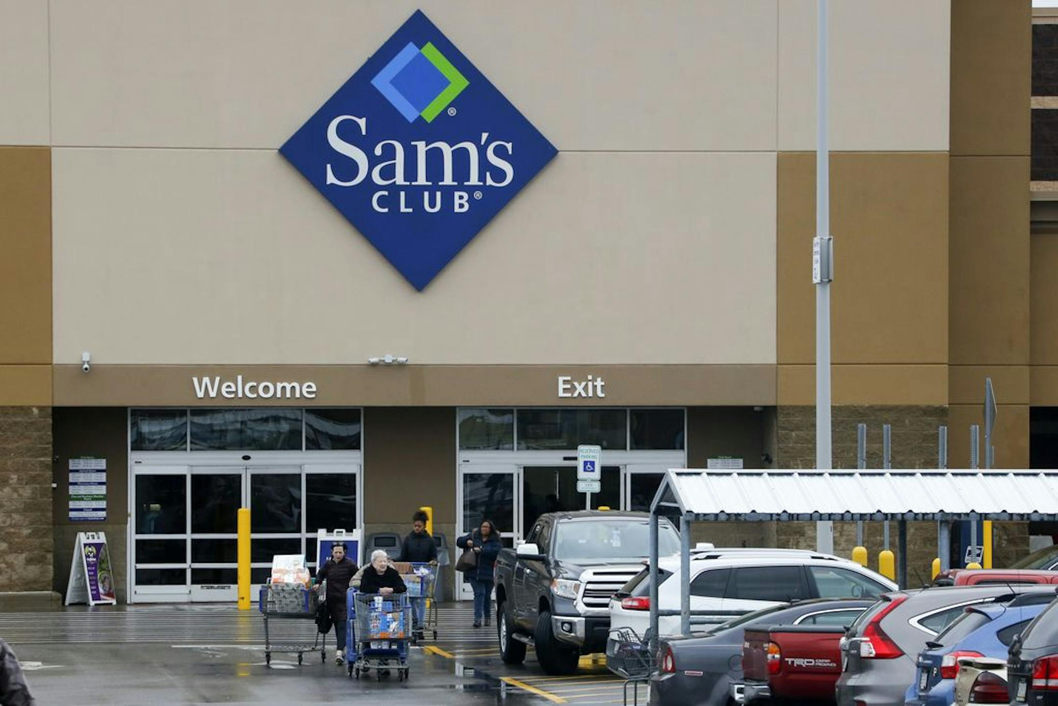 File- This Feb. 23, 2018, file photo shows shoppers leaving a Sam's Club in Pittsburgh. Walmart's Sam's Club is teaming up with several health care companies to offer discounts on everyday care its customers might delay or skip because of the cost. Starting early October, Sam's Club members in Michigan, Pennsylvania and North Carolina, will be able to buy one of four bundles of health care services ranging in annual fees from $50 for individuals to $240 for a family of up to six members. The pil