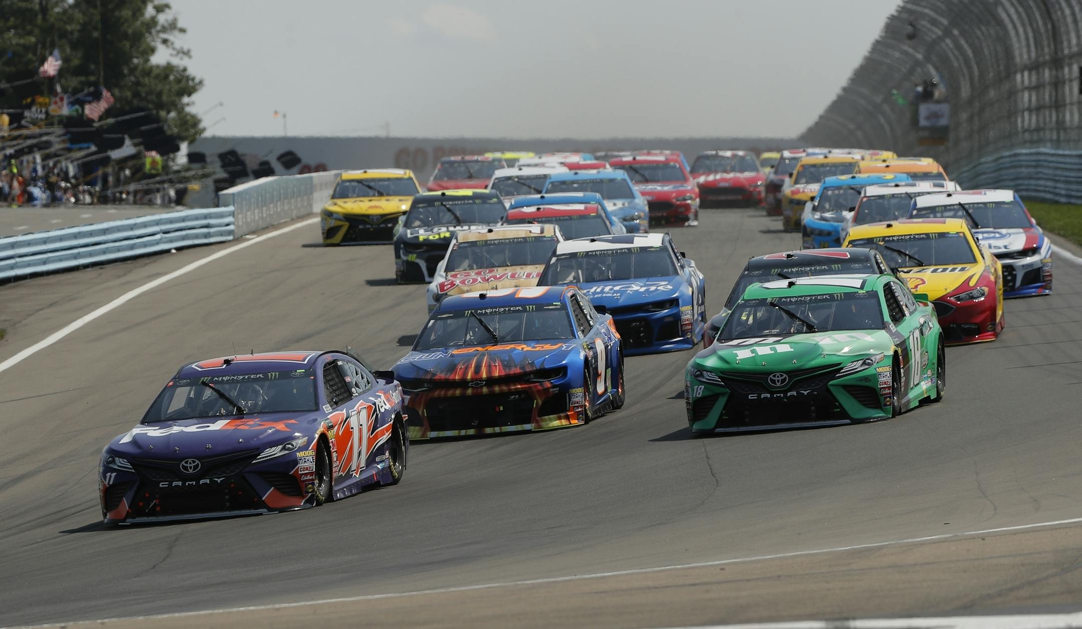 Denny Hamlin (11), Chase Elliott (9) and Kyle Busch (18) lead the pack into turn one at the start of a NASCAR Cup series auto race, Sunday, Aug. 5, 2018, in Watkins Glen, N.Y. (AP Photo/Julie Jacobson)