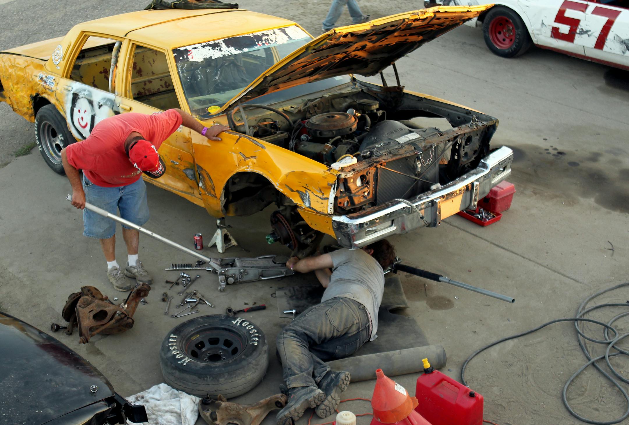 Jay Barta, right, of Burnsville, and his father Dennis Barta, of Richfield, work on their racecar in the pit area during the "Pack the Stands" event at Raceway Park in Shakopee, Minn., on Sunday, August 4, 2013. ] (ANNA REED/STAR TRIBUNE) anna.reed@startribune.com (cq)