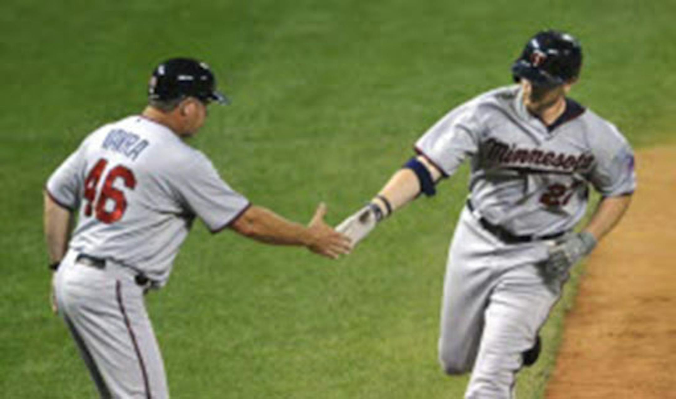 Chris Parmelee was congratulated by third base coach Joe Vavra in the eighth inning after the first of his two home runs. Parmelee had three hits in the Twins' 8-7 loss to Cleveland at Progressive Field.