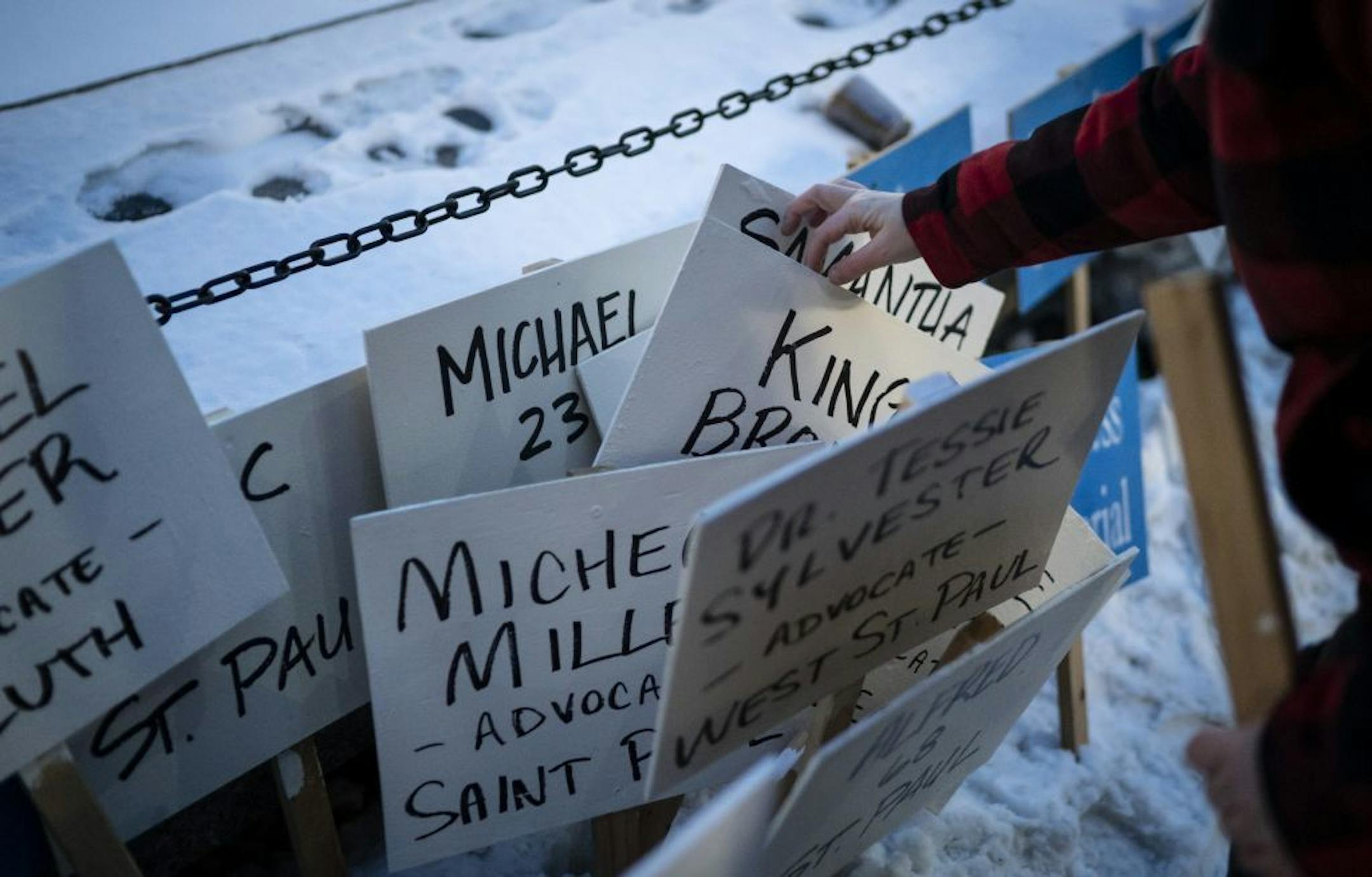 Sam Stoltz looked for names she recognized on sign to carry in the silent Homeless Memorial March that recognized the 190 homeless, previously homeless and advocates for the homeless that died in 2019 on Thursday, December 19, 2019 through downtown Minneapolis, Minn.