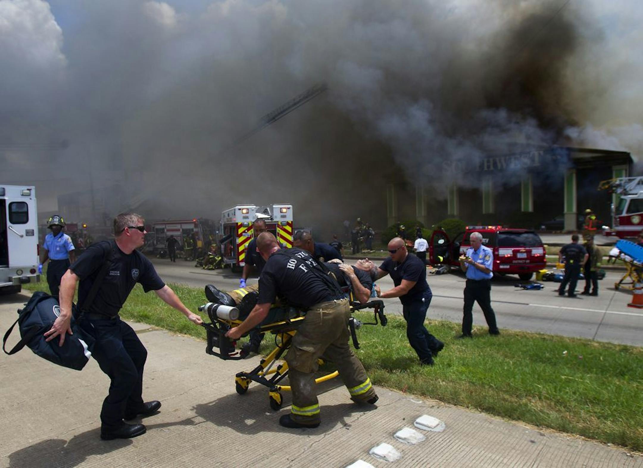 A firefighter is wheeled to an ambulance after fighting a fire at the Southwest Inn, Friday, May 31, 2013, in Houston. Four firefighters have died and at least five people have been hospitalized. (AP Photo/Houston Chronicle, Cody Duty) MANDATORY CREDIT