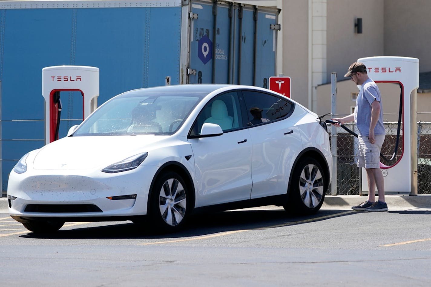 FILE - A Tesla owner charges his vehicle at a charging station in Topeka, Kan., Monday, April 5, 2021. Tesla reported 273 crashes involving partially automated driving systems, according to statistics released by U.S. safety regulators on Wednesday, June 15, 2022. But the National Highway Traffic Safety Administration cautioned against using the numbers to compare automakers, saying it didn't weigh them by the number of vehicles from each manufacturer that use the systems, or how many miles those vehicles traveled. (AP Photo/Orlin Wagner, File)