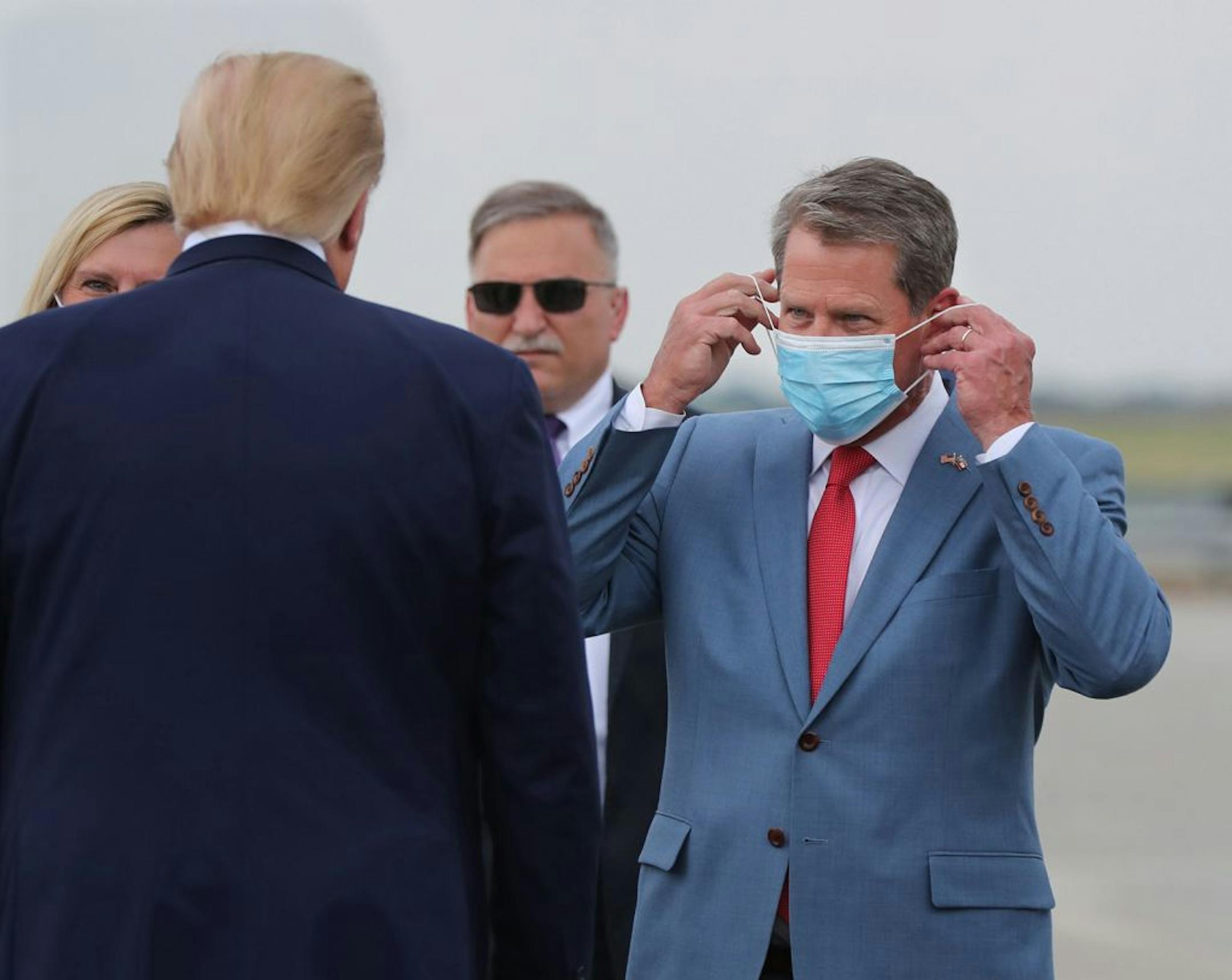 Georgia Gov. Brian Kemp, right, greeted President Donald Trump as he visited Georgia to talk about an infrastructure overhaul at the UPS Hapeville hub at Hartsfield-Jackson International Airport in Atlanta on July 15, 2020. Over the weekend, Trump escalated his attacks on Kemp, saying he was "ashamed" to have endorsed him in 2018.