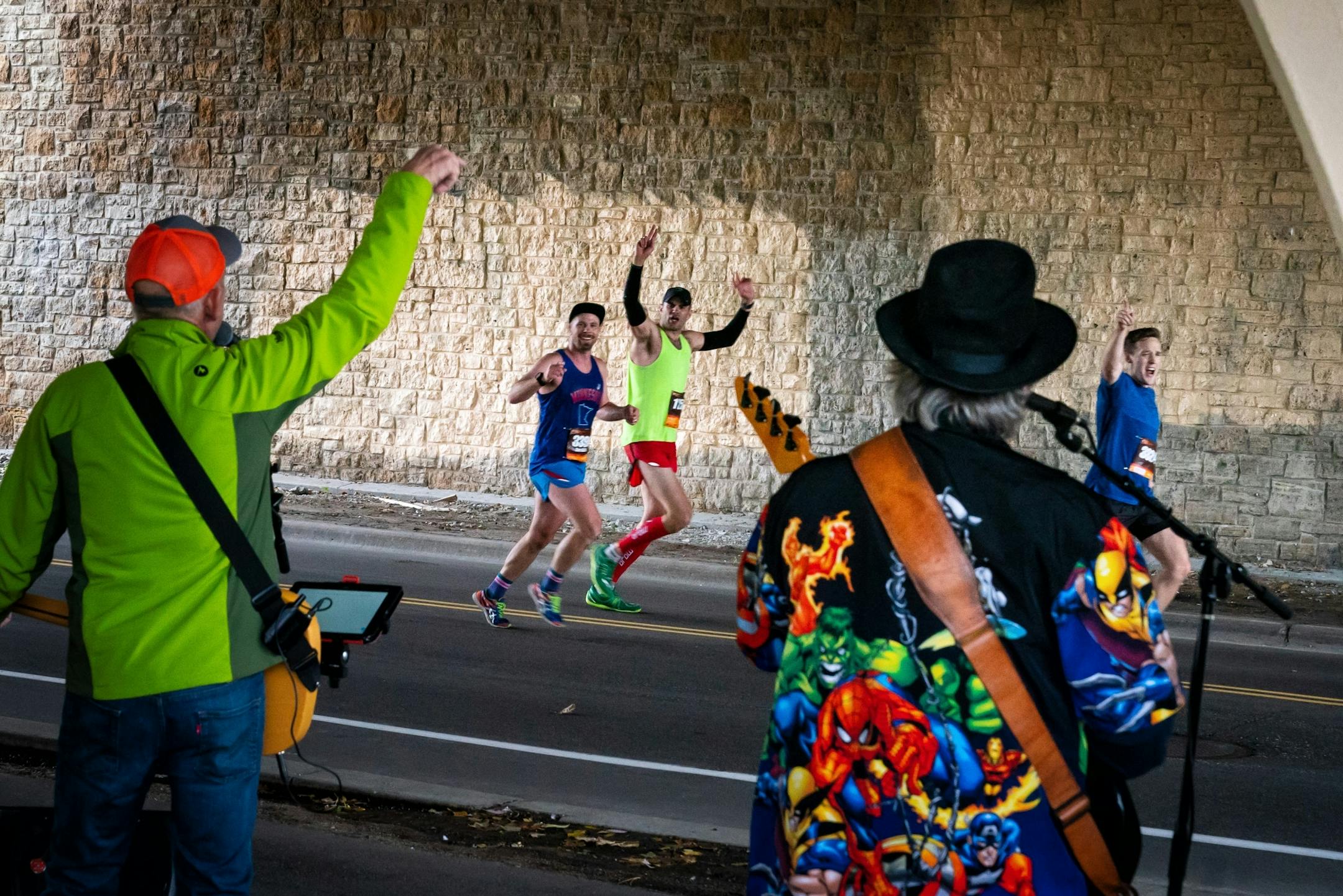 Runners cheered as the Burner Band/Cornhole Committee rocked "Sweet Home Alabama" and "Hey Joe" from under the Lake St Bridge along Mississippi River Blvd near mile marker 21 during the Twin Cities Marathon.
