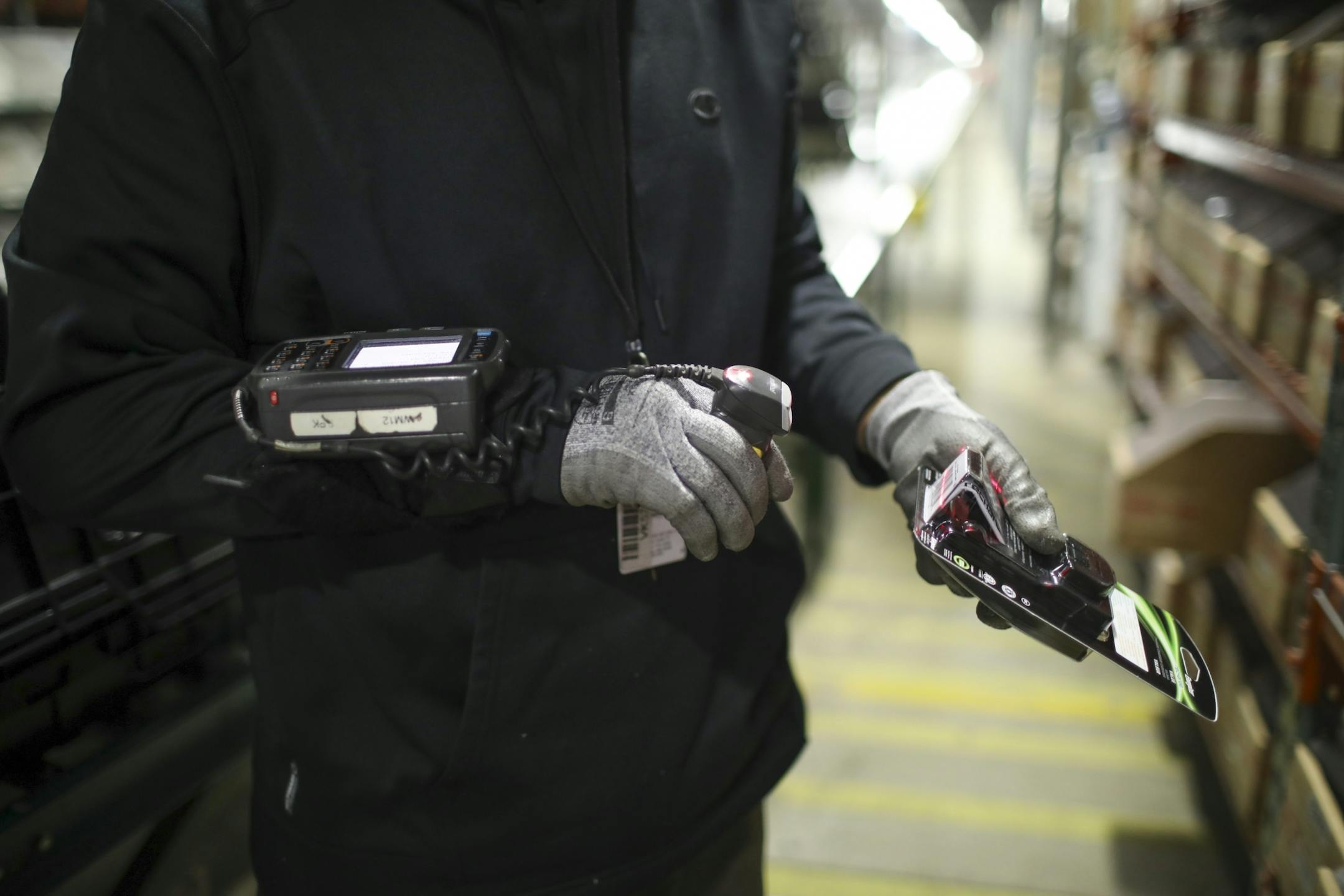While picking smaller items for an order, Mustafa Hassan used a scanner attached to his index finger connected to a keypad mounted on his wrist in the Best Buy distribution center Monday afternoon.