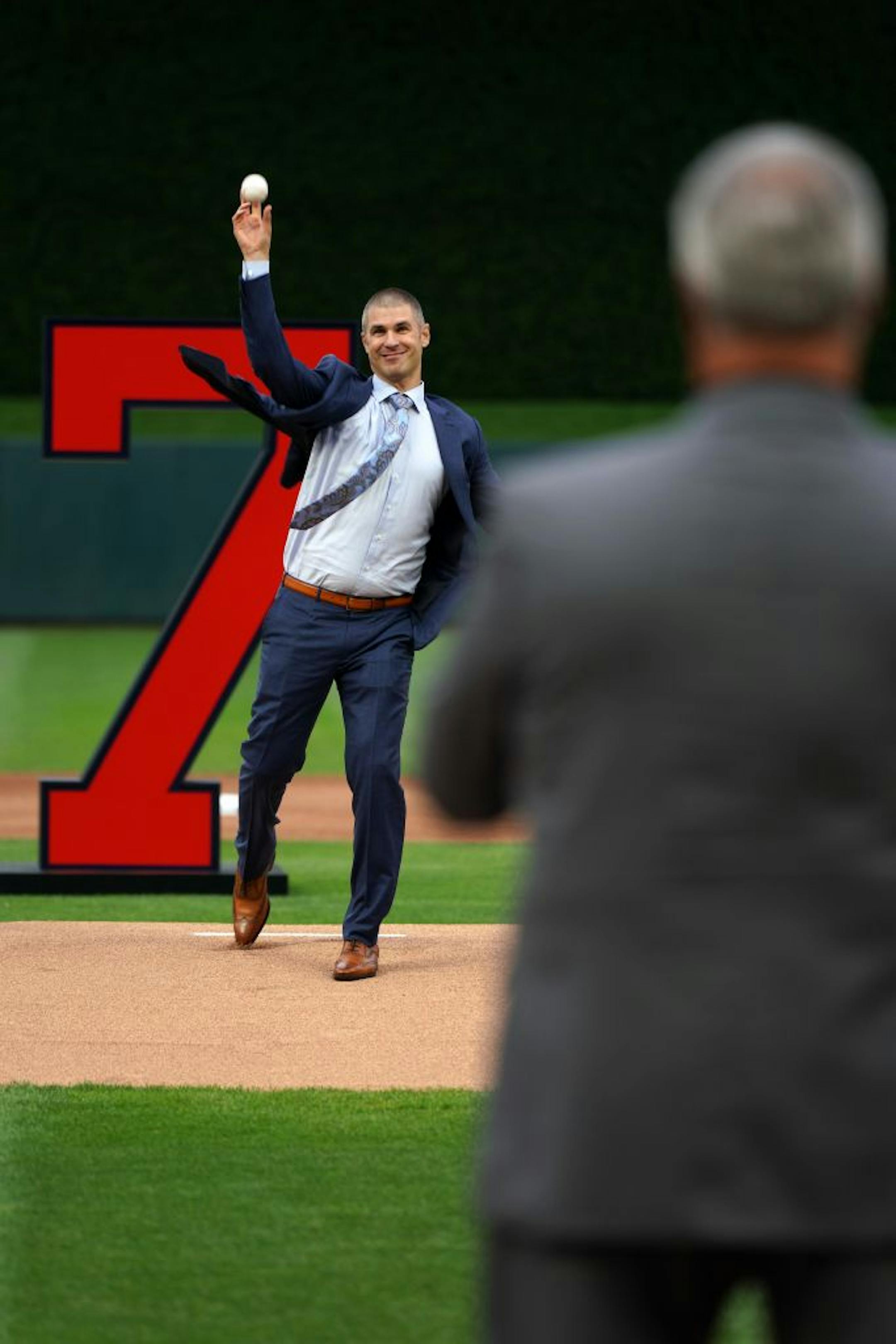 Former Minnesota Twins star Joe Mauer's threw a ceremonial first pitch to his dad Jake during a pregame ceremony to retire his number 7 Saturday.