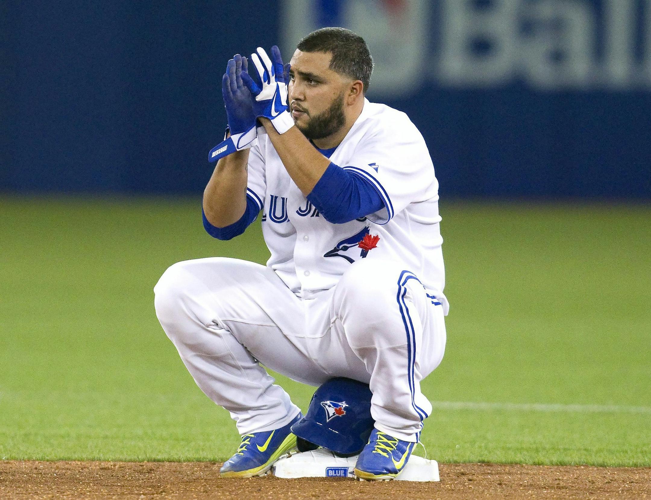 Toronto Blue Jays' Dioner Navarro sits on his helmet at second base after doubling and driving home teammate Edwin Encarnacion during the sixth inning of a baseball game against the Minnesota Twins, Tuesday, Aug. 4, 2015 in Toronto. (Fred Thornhill/The Canadian Press via AP) MANDATORY CREDIT