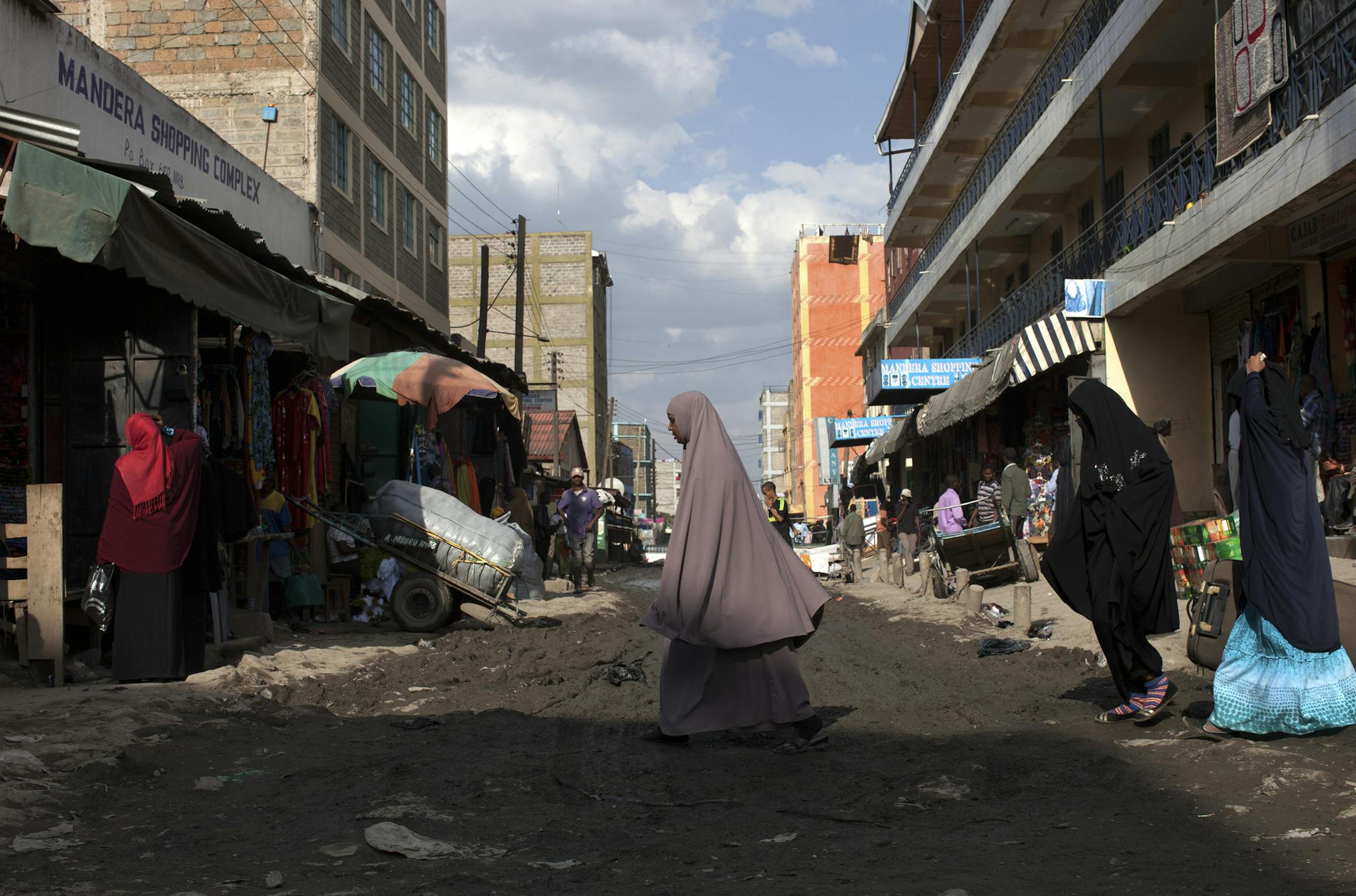 Women cross the street in the Somali enclave of Eastleigh, which serves at the financial capital for the Shabab militant group, in Nairobi, Kenya, Sept. 27, 2013. The Shabab, which claimed responsibility for the deadly mall siege in Nairobi, make money through various illegal endeavors and even employ a team of accountants. (Tyler Hicks/The New York Times)