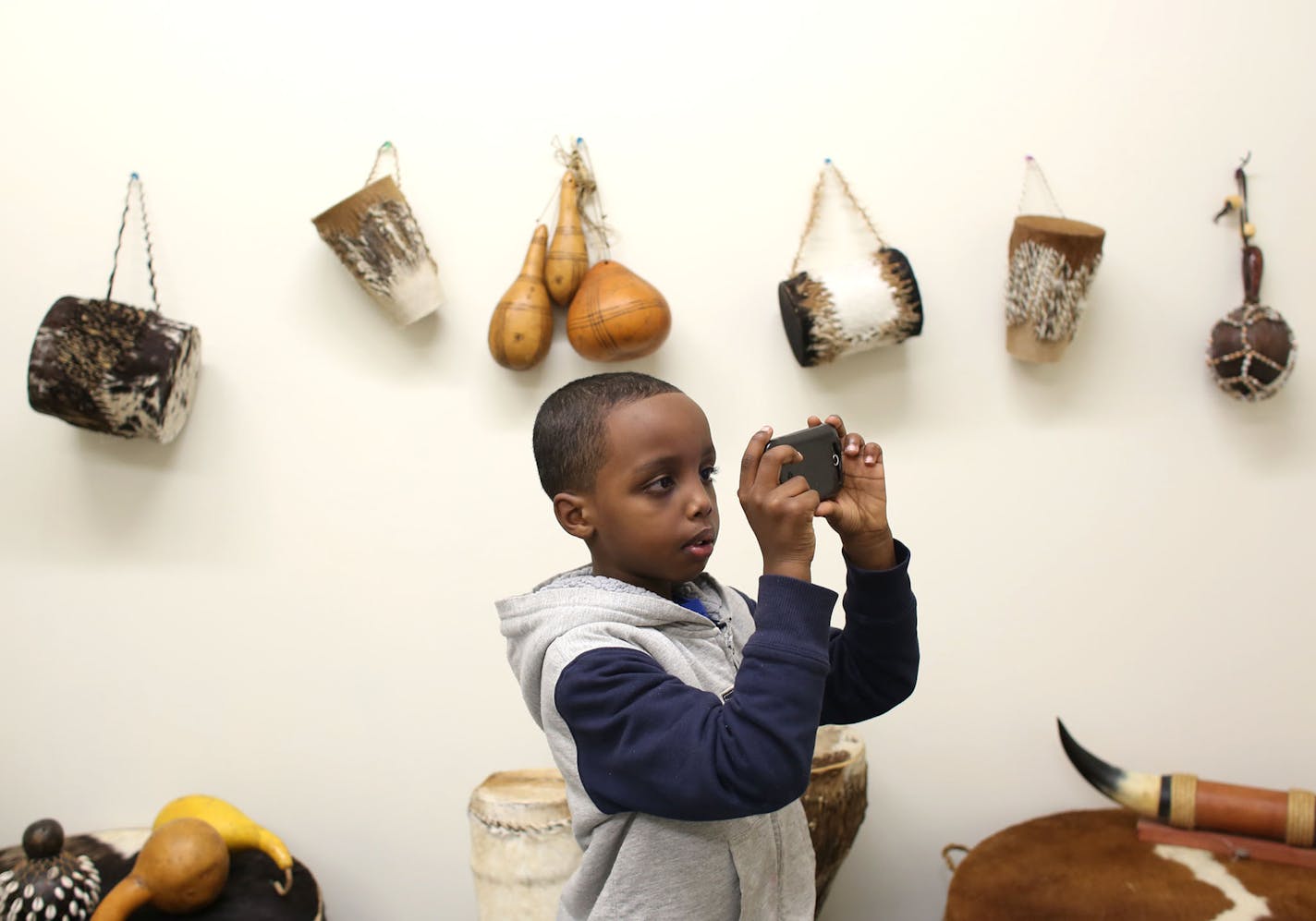 Suber Aden, 6, of St. Paul, took pictures of traditional Somali instruments during the grand opening of the Somali Artifact and Cultural Museum in Minneapolis Min., Saturday, October 19, 2013 ] (KYNDELL HARKNESS/STAR TRIBUNE) kyndell.harkness@startribune.com