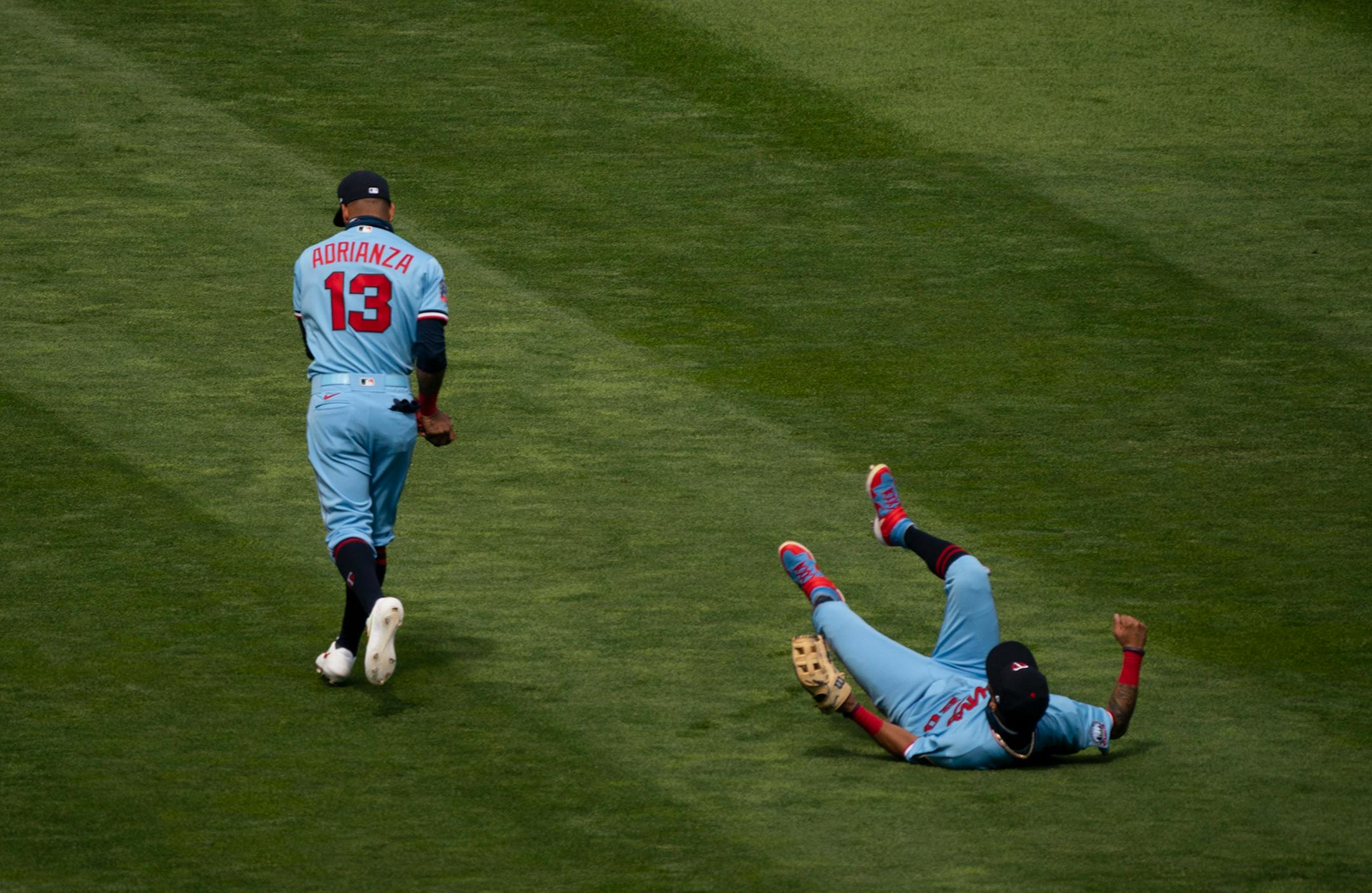 Minnesota Twins third baseman Ehire Adrianza (13) followed through after caught a pop fly by Cleveland Indians third baseman Jose Ramirez in front of Minnesota Twins left fielder Eddie Rosario (20) for the first out of the ninth inning.