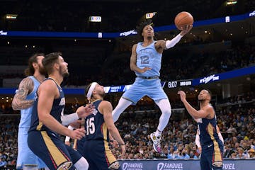 Memphis guard Ja Morant got between New Orleans defenders on Saturday.