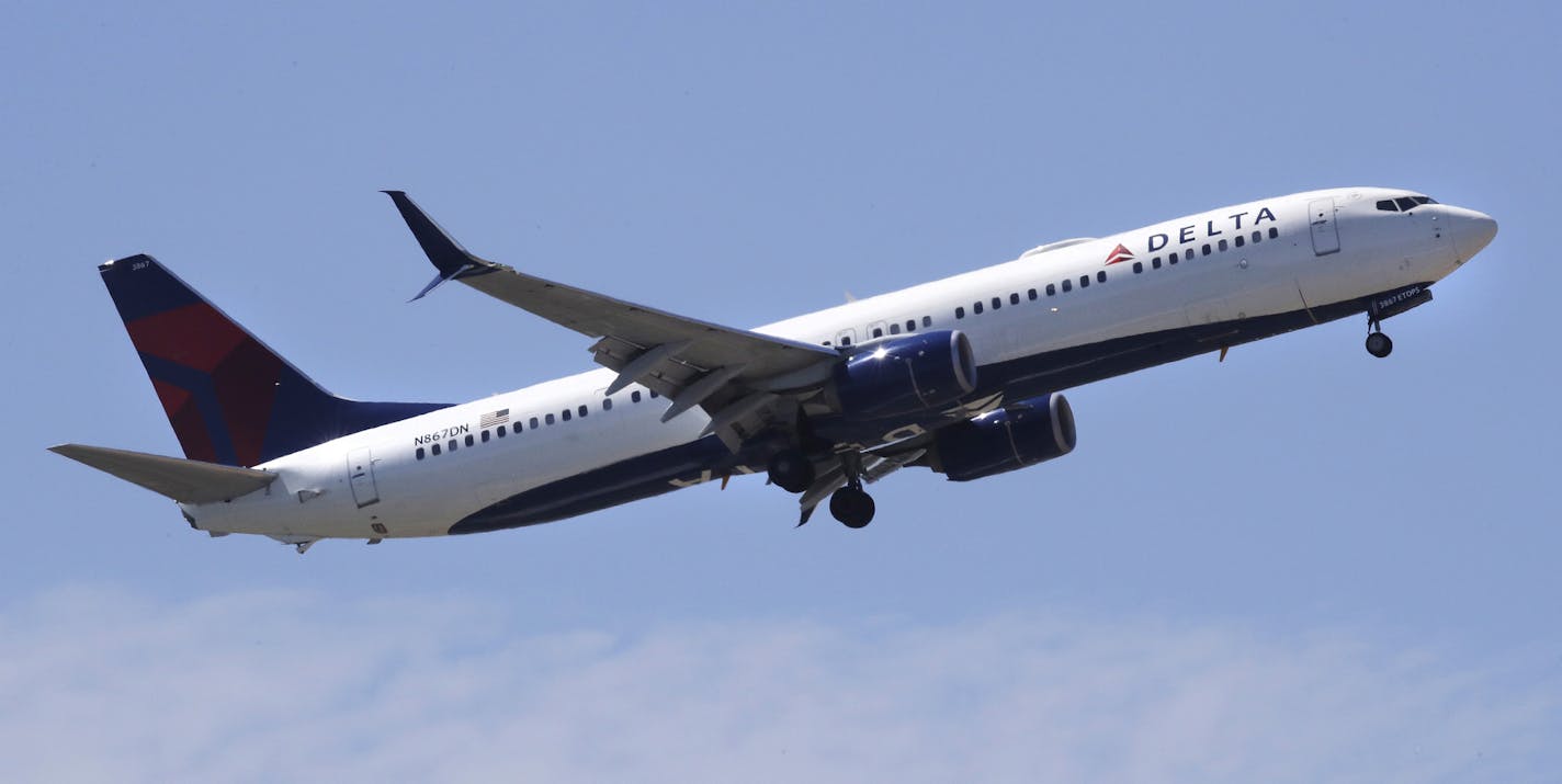 FILE- In this May 24, 2018, file photo a Delta Air Lines passenger jet plane, a Boeing 737-900 model, approaches Logan Airport in Boston. Airlines are seeing a sharp drop in bookings and a rise in cancellations in recent days as the coronavirus outbreak continues to spread, and they are responding by slashing flights and freezing hiring. Normally airlines try to lure reluctant customers by discounting fares, but that won't work in the face of the COVID-19 outbreak. (AP Photo/Charles Krupa, File)