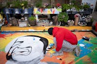 Antonio Jenkins paints a new mural of George Floyd on the spot he was murdered on the eve of the four year anniversary of Floyd’s murder in Minneapo