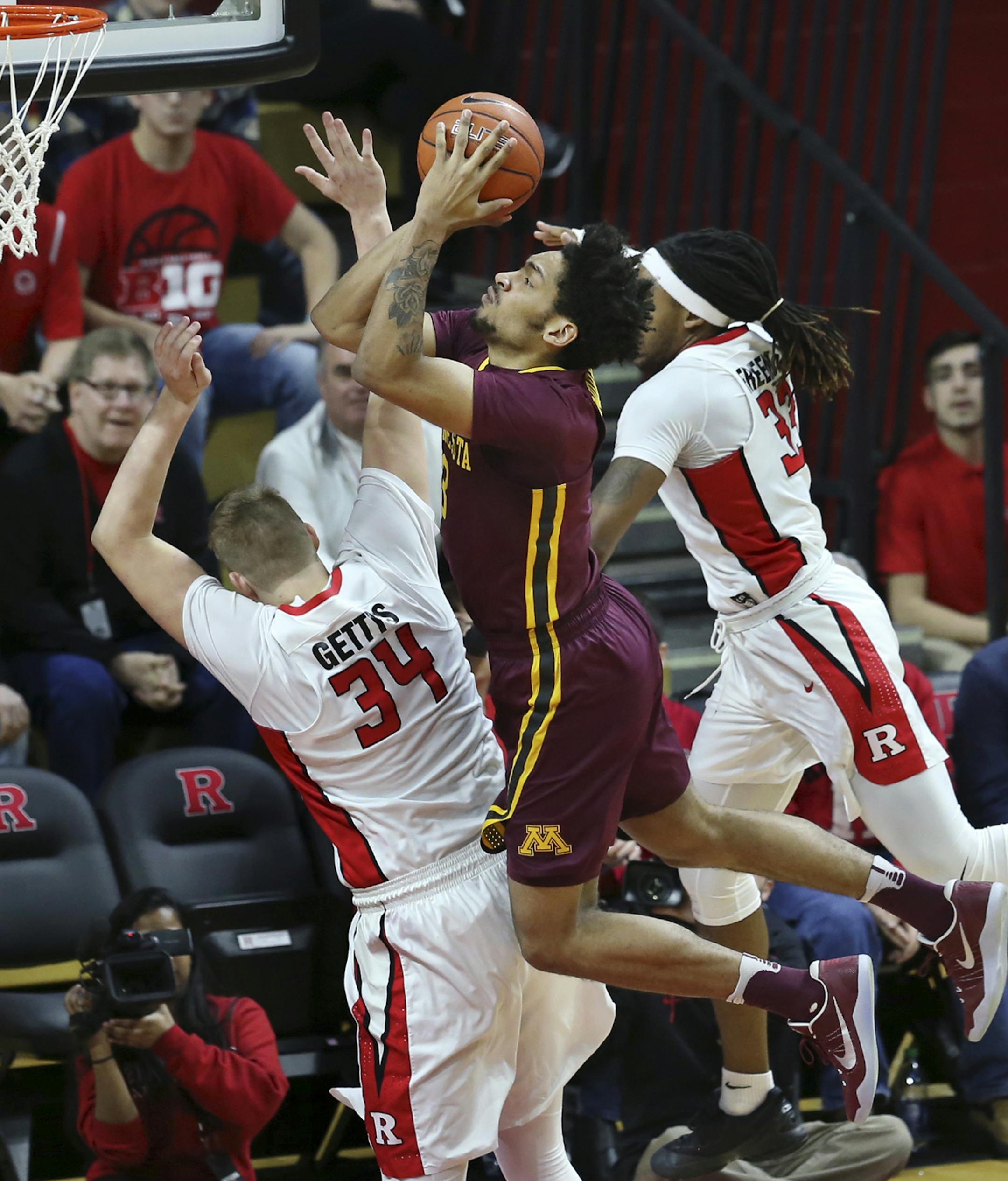 Gophers forward Jordan Murphy split the defense of Rutgers’ C.J. Gettys and Deshawn Freeman on his way to the basket.