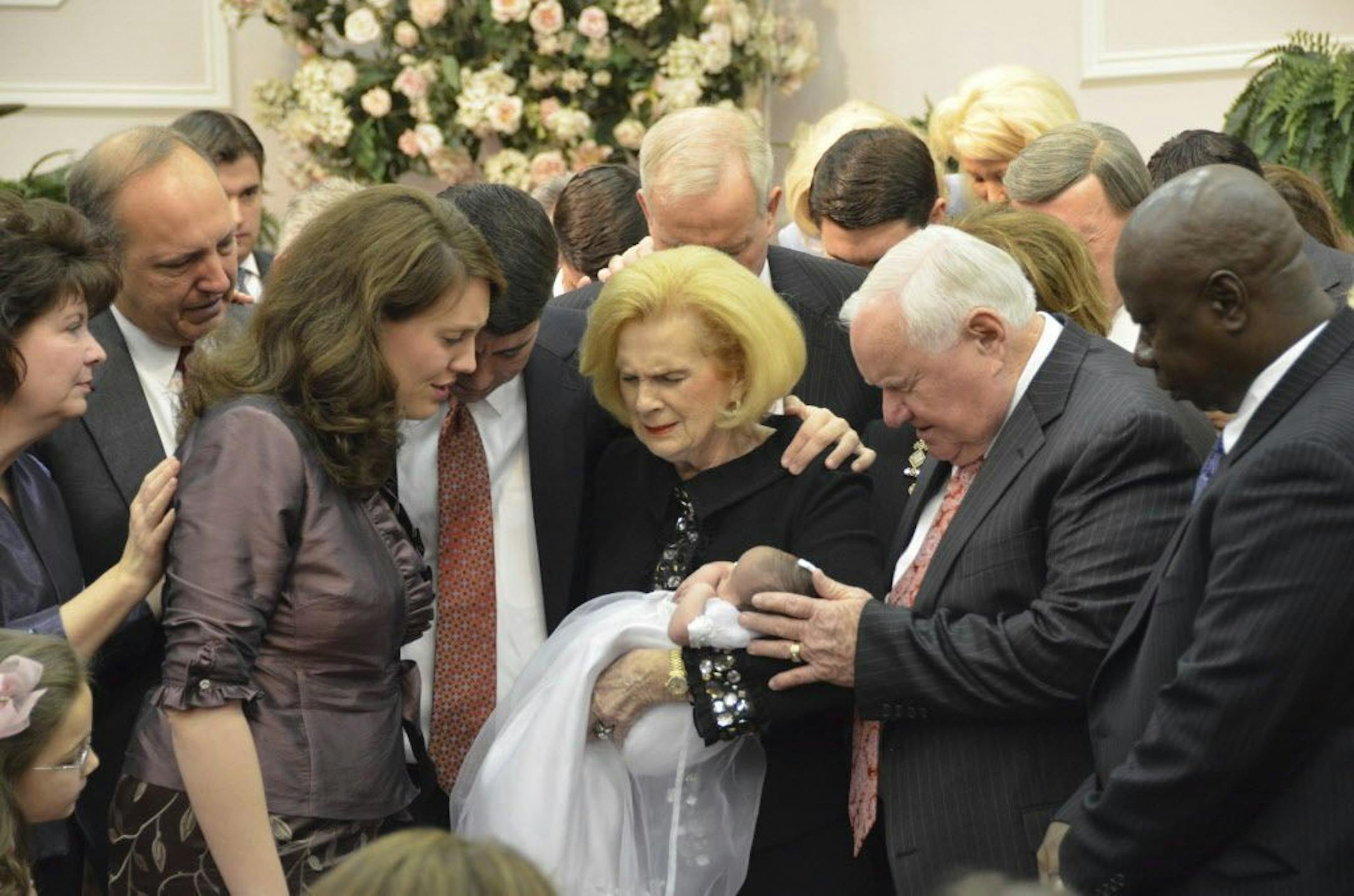 In this 2012 photo provided by a former member of the church, Word of Faith Fellowship leader Jane Whaley, center, holds a baby, accompanied by her husband, Sam, center right, and others during a ceremony in the church's compound in Spindale, N.C. From all over the world, they flocked to this tiny town in the foothills of the Blue Ridge Mountains, lured by promises of inner peace and eternal life. What many found instead: years of terror _ waged in the name of the Lord.
