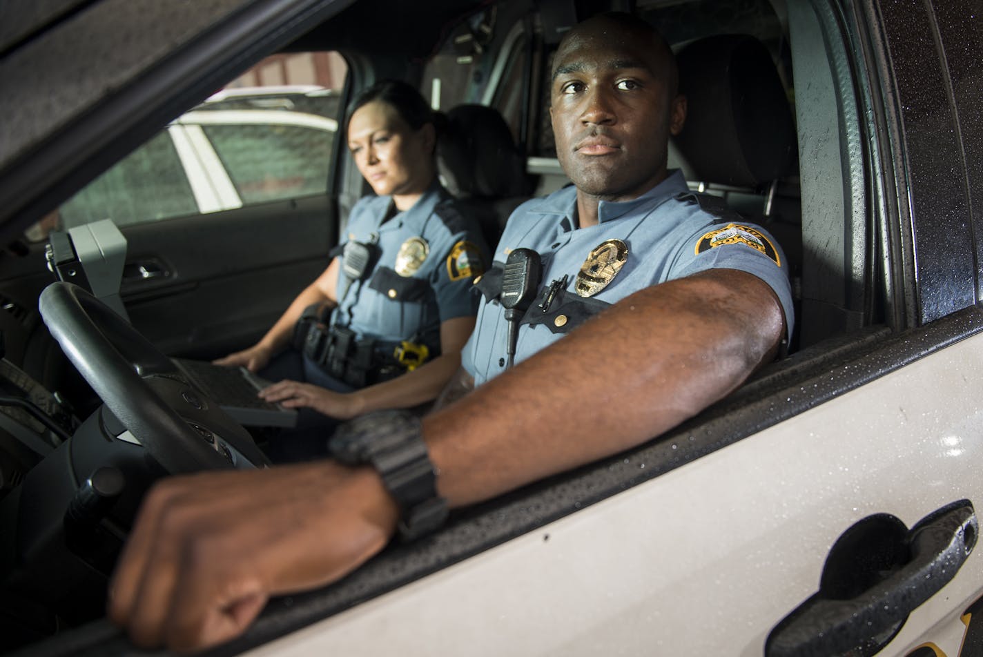 St. Paul police officers Chenoa Fields, left, and Chris Hamblin sat in their police cruiser for a portrait before leaving the Eastern District Station to go on patrol on July 14, 2016.