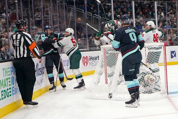 Seattle Kraken right wing Nathan Bastian (14) fights with Minnesota Wild center Connor Dewar (52) during the first period of an NHL hockey game Thursd