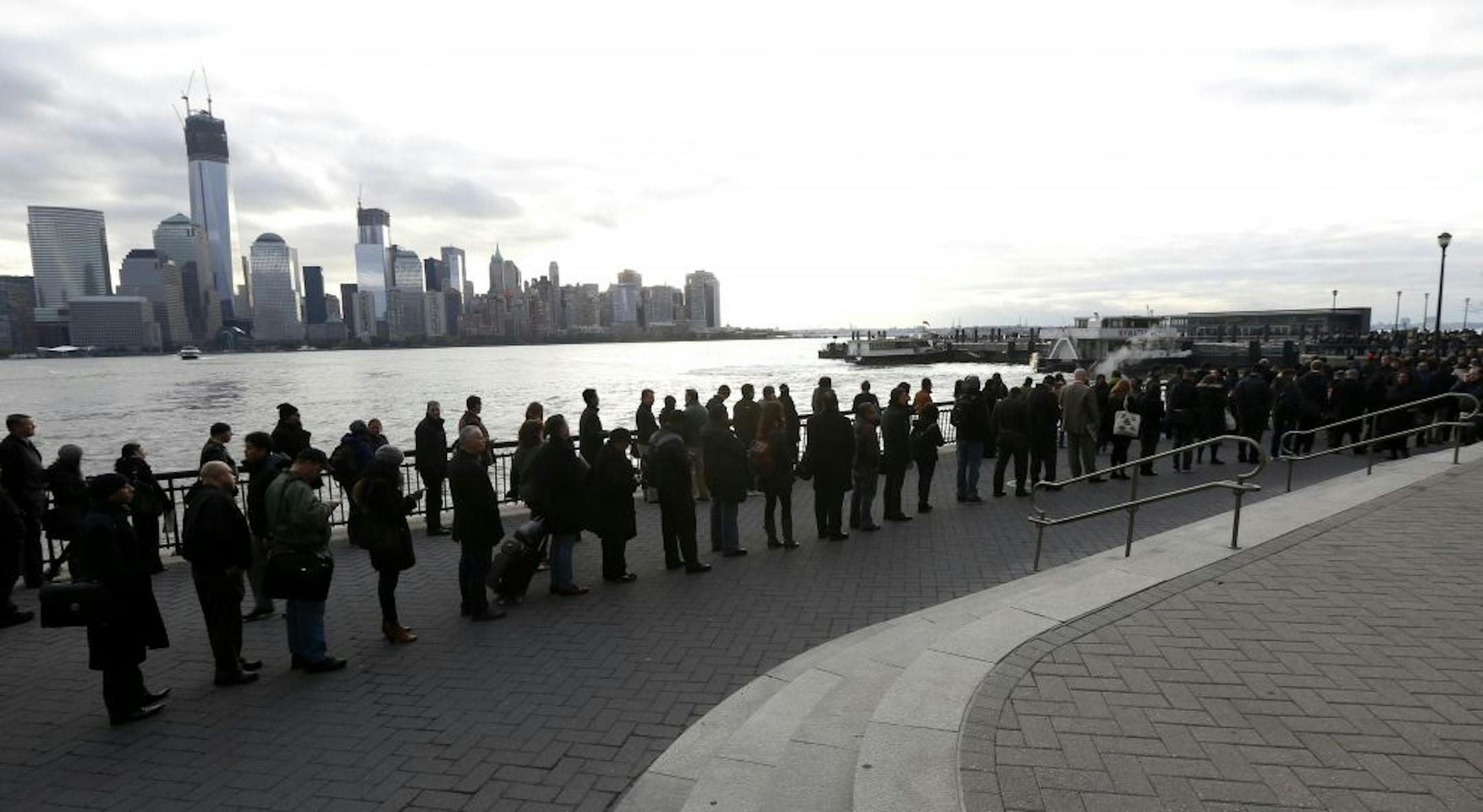 A long line forms at the ferry terminal in Jersey City, N.J., as people commute toward New York City, Monday, Nov. 5, 2012. Flooding caused by Superstorm Sandy has halted mass transportation in the northern New Jersey region with train service to New York completely shutdown.
