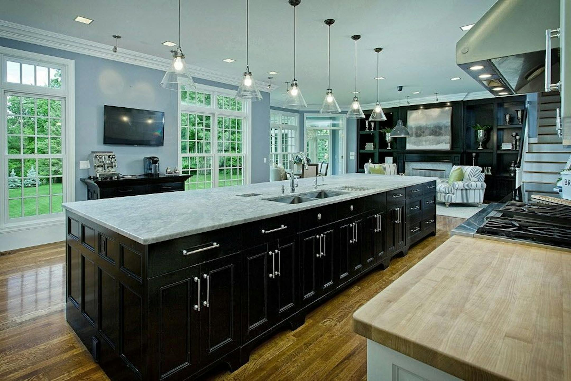 The updated modern kitchen features a marble-topped island, butcher block counters, top-of-the-line appliances and a coffee bar.