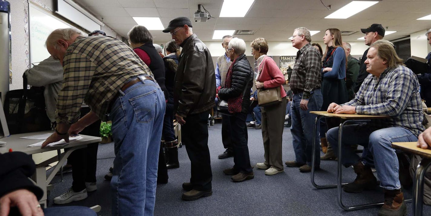 FILE - In this March 1, 2016 file photo, Republicans register in their precinct as they caucus at Bloomington Jefferson High School in Bloomington, Minn. Minnesota's political caucuses are likely to be far less rowdy this year _ and far less crowded than in the past. That's because the state has shifted its presidential preference process away from caucuses and into a primary election that's part of Super Tuesday next month. (AP Photo/Jim Mone File)