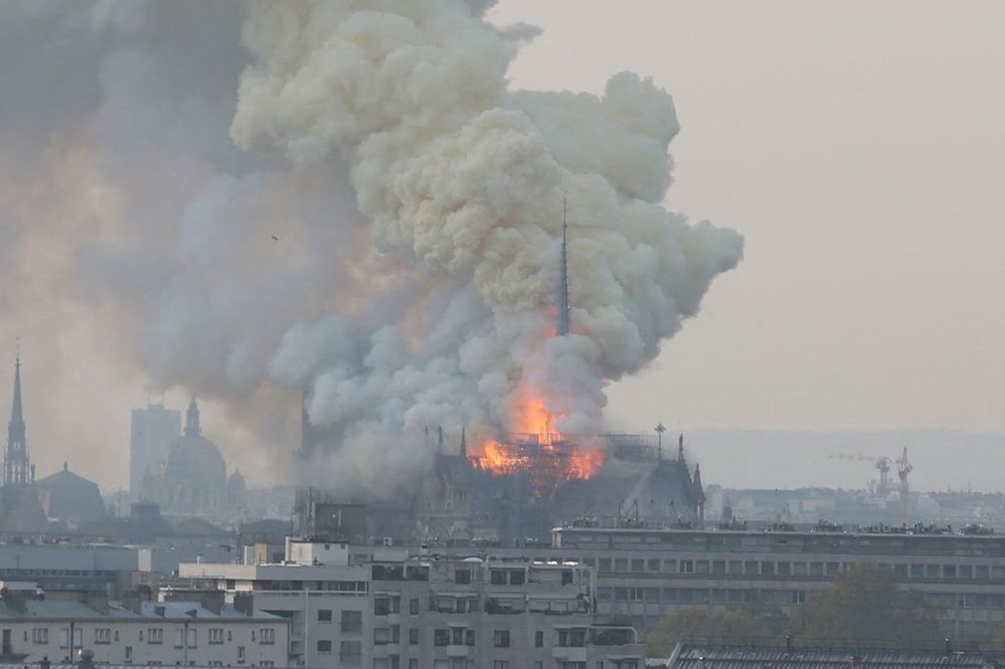 Smoke and flames rise during a fire at the landmark Notre Dame Cathedral in central Paris, France on Monday, April 15, 2019, potentially involving renovation works being carried out at the site, the fire service said.