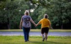Jody Brennan and her daughter Maddie, who has Down syndrome and lives at a Bridges MN group home, on a walk at Memorial Park in Shakopee, Minn. ] CARL