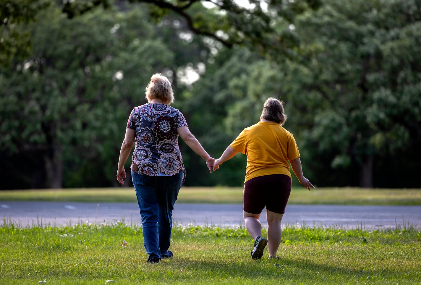 Jody Brennan and her daughter Maddie, who has Down syndrome and lives at a Bridges MN group home, on a walk at Memorial Park in Shakopee, Minn. ] CARLOS GONZALEZ • carlos.gonzalez@startribune.com