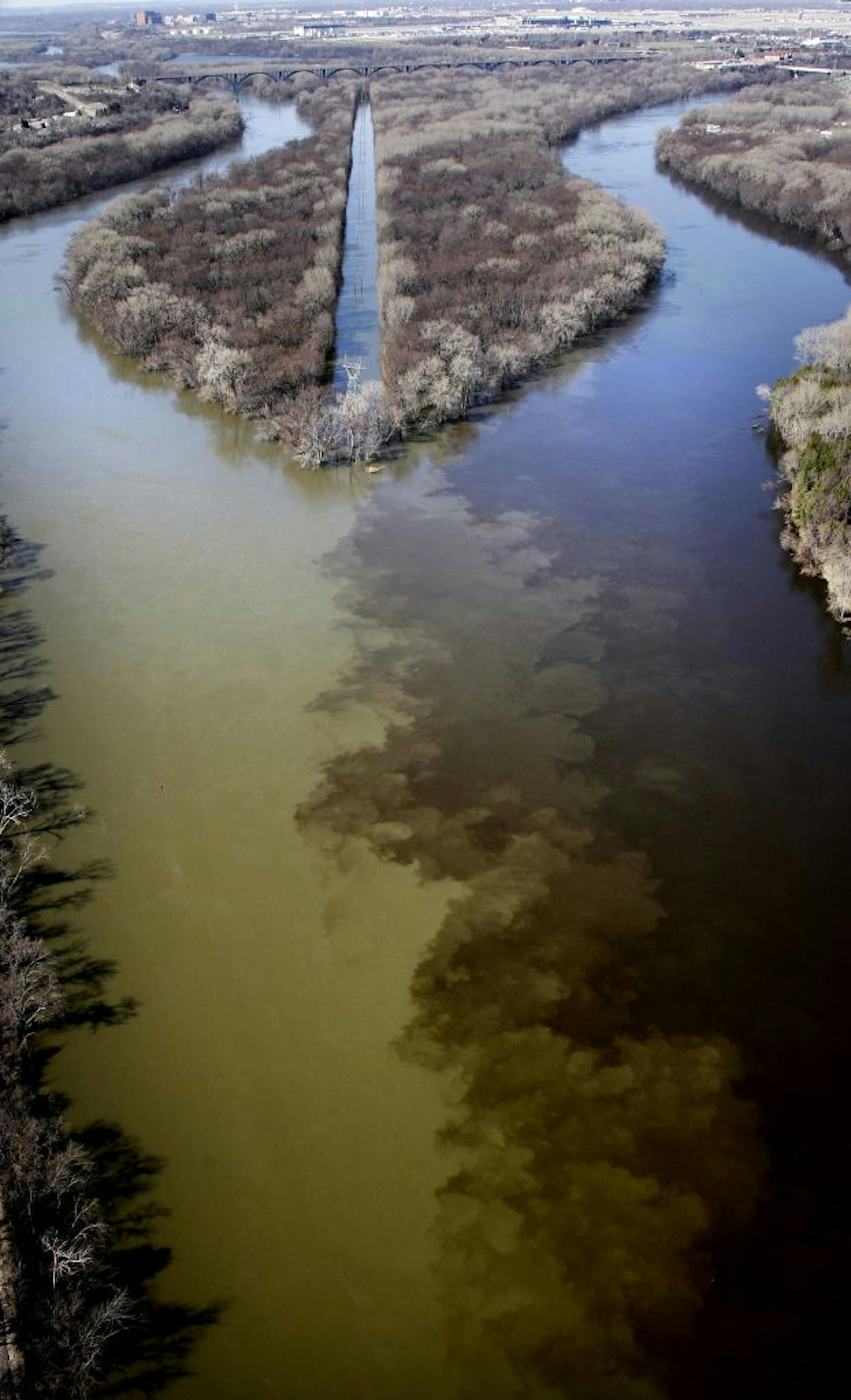 The sediment flowing out of the Minnesota River (left) is clear in this photo of the confluence of the Minnesota (left) and Mississippi (right) Rivers near Fort Snelling.
