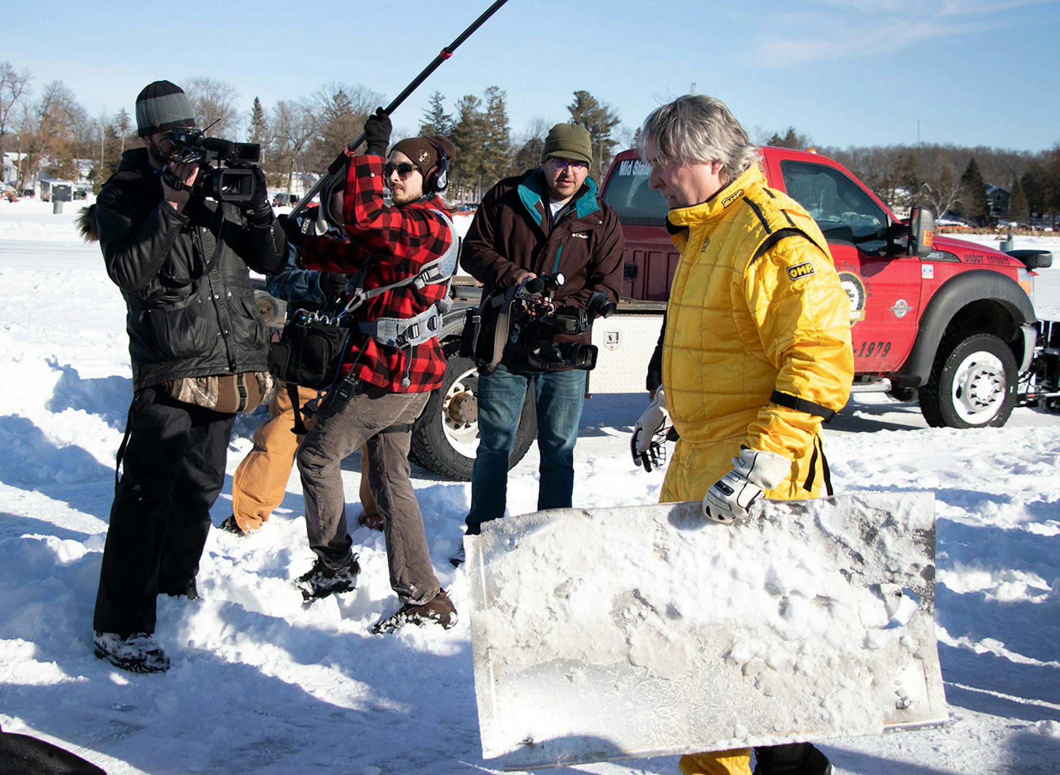 Kurt Anderson carries a piece of the Arctic Arrow upon his return to the crash site after being checked over by medical personnel on Sunday, Feb. 16, 2020 on Bear Lake in Manawa, WI.